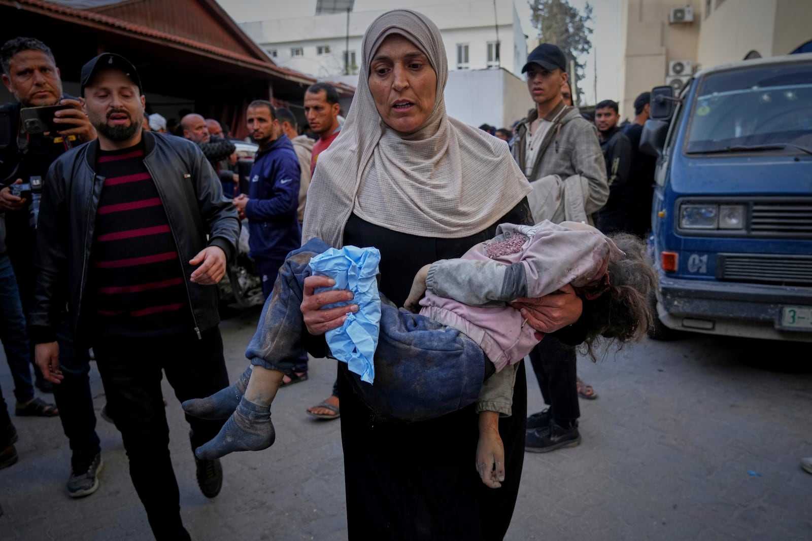 A woman carries the body of a child to Al-Ahli hospital following overnight Israeli airstrikes across the Gaza Strip, in Gaza City, Tuesday, March 18, 2025. (AP Photo/Jehad Alshrafi)