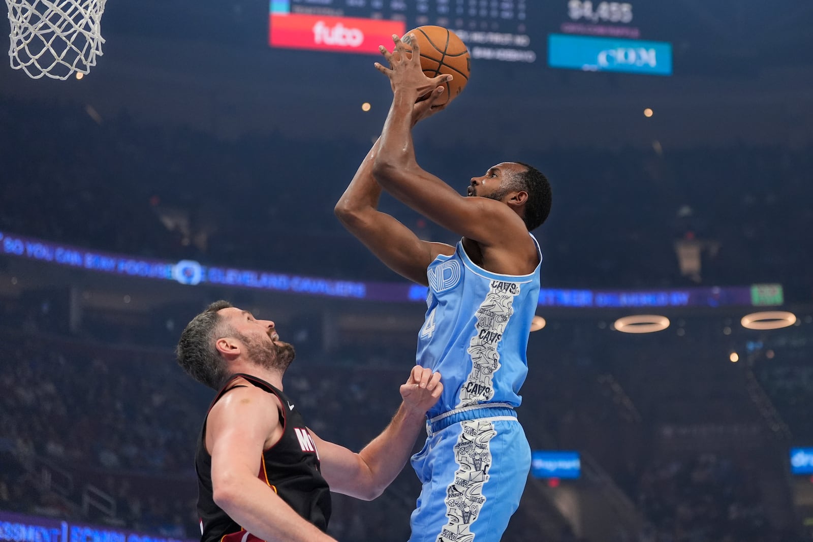 Cleveland Cavaliers forward Evan Mobley, right, shoots over Miami Heat forward Kevin Love, left, in the first half of an NBA basketball game Wednesday, March 5, 2025, in Cleveland. (AP Photo/Sue Ogrocki)