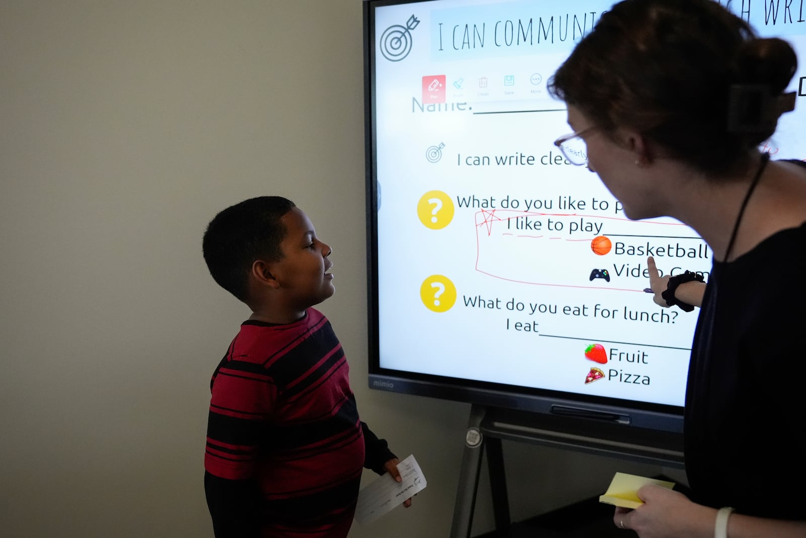 Dylan Martínez-Ramírez, left, sounds out a sentence as instructed by Culturally & Linguistically Diverse Education teacher Sarah Pearlstein at Del Mar Academy, Thursday, Aug. 29, 2024, in Aurora, Colo. (AP Photo/Godofredo A. Vásquez)