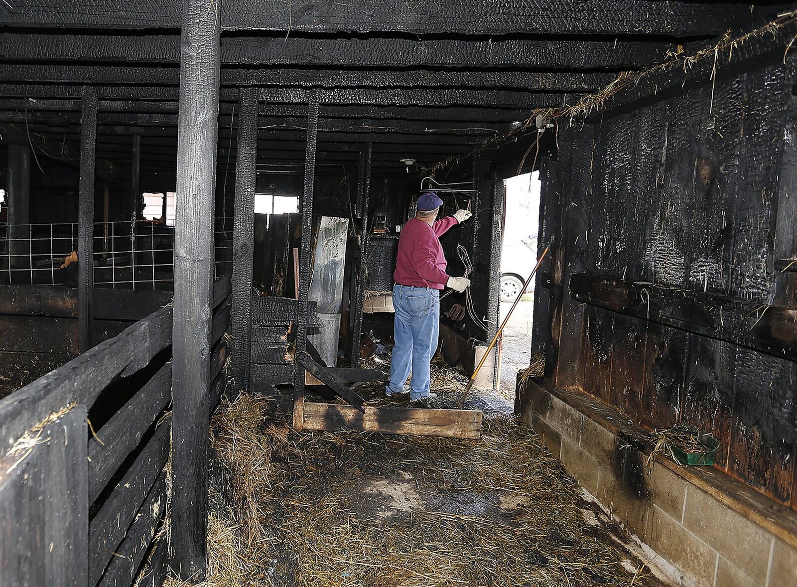 Ed McCullough sorts through the debris inside the On-the-Rise barn that was destroyed by fire Tuesday evening. On-the-Rise is a nonprofit that works with at-risk students on the farm to teach them life skills and hard work. Bill Lackey/Staff