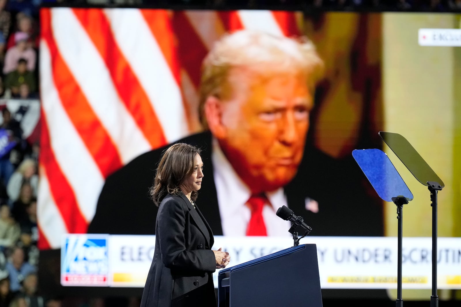 Democratic presidential nominee Vice President Kamala Harris speaks as an image of Republican presidential nominee former President Donald Trump appears on screen during a campaign rally at Erie Insurance Arena, in Erie, Pa., Monday, Oct. 14, 2024. (AP Photo/Jacquelyn Martin)