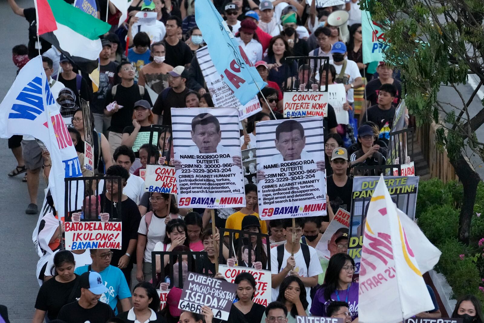 Protesters hold pictures of former President Rodrigo Duterte's as they call for justice to victims of the war on drugs during his administration in Quezon city, Philippines on Friday, March 14, 2025. (AP Photo/Aaron Favila)