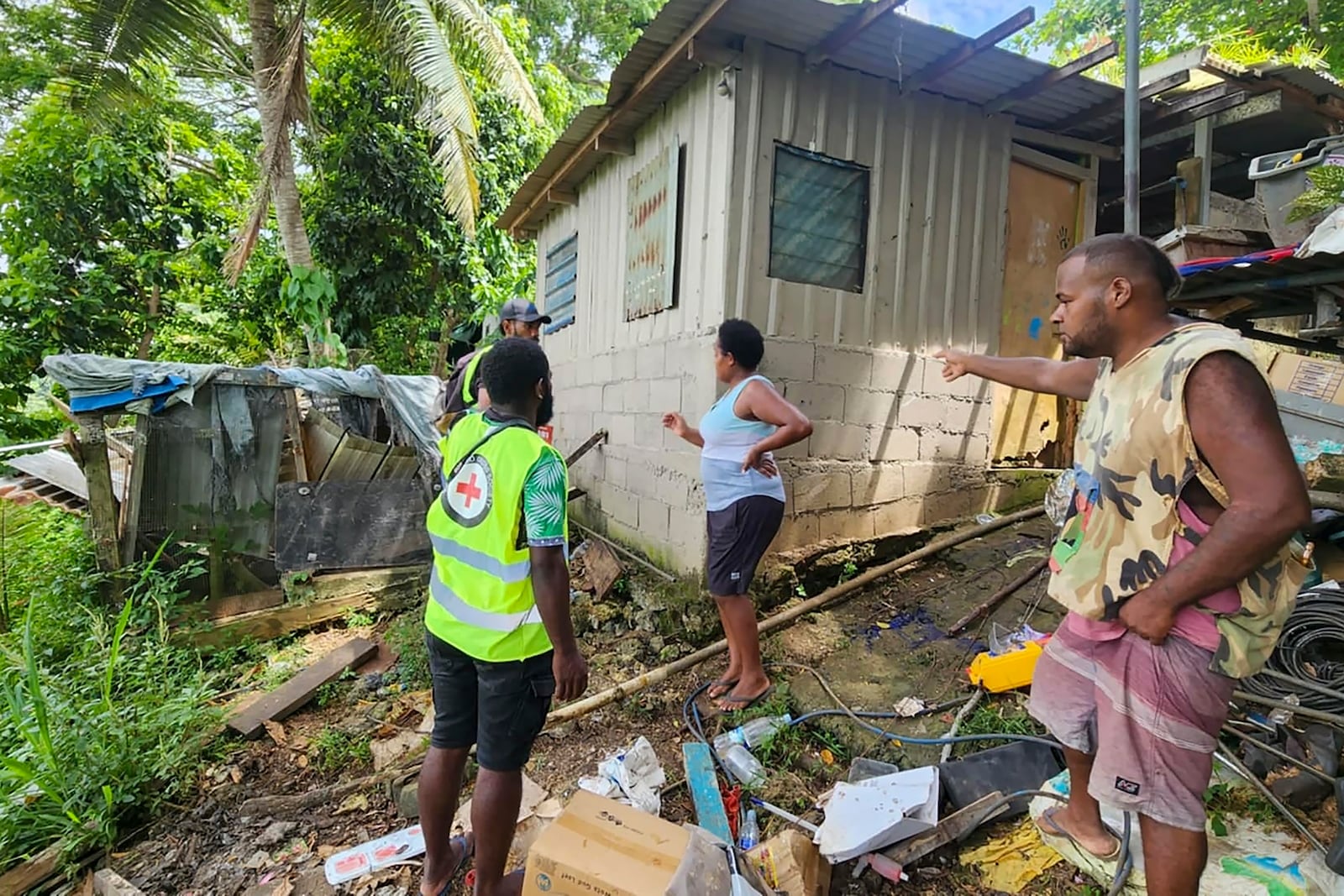 In this photo released by Vanuatu Red Cross Society, Red Cross volunteers assist locals as they inspect their damaged house in Efate, Vanuatu, Thursday, Dec. 19, 2024, following a powerful earthquake that struck just off the coast of Vanuatu in the South Pacific Ocean. (Vanuatu Red Cross Society via AP)