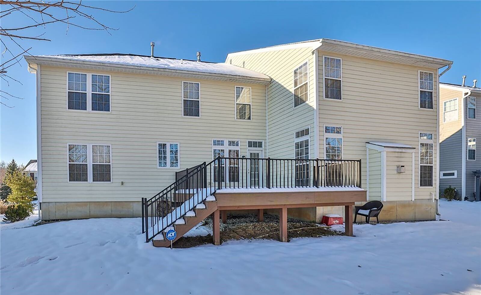 The rear of the home has a composite deck with metal railings.