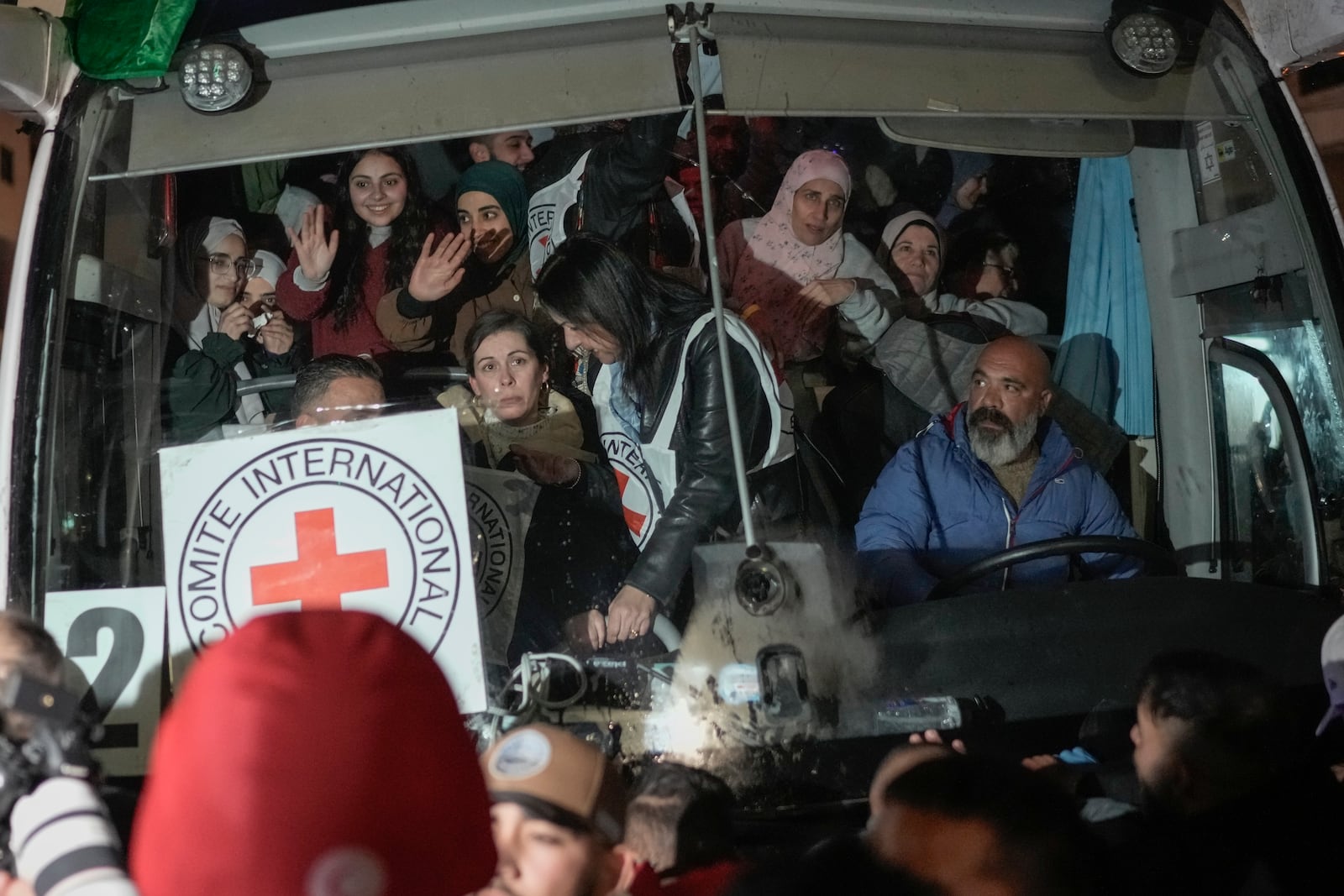 FILE - Palestinian female prisoners, who were released from an Israeli prison as part of a ceasefire deal between Israel and Hamas, wave from inside a bus as they arrive in the West Bank city of Beitunia, Monday, Jan. 20, 2025. (AP Photo/Leo Correa, File)