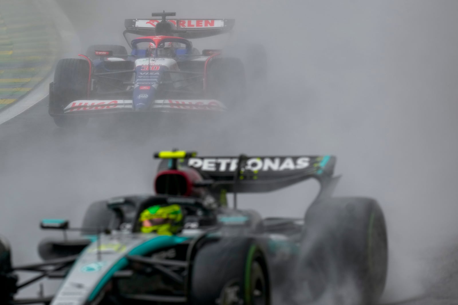 RB driver Liam Lawson of New Zealand chases Mercedes driver Lewis Hamilton of Britain during the Brazilian Formula One Grand Prix at the Interlagos race track in Sao Paulo, Sunday, Nov. 3, 2024. (AP Photo/Andre Penner)