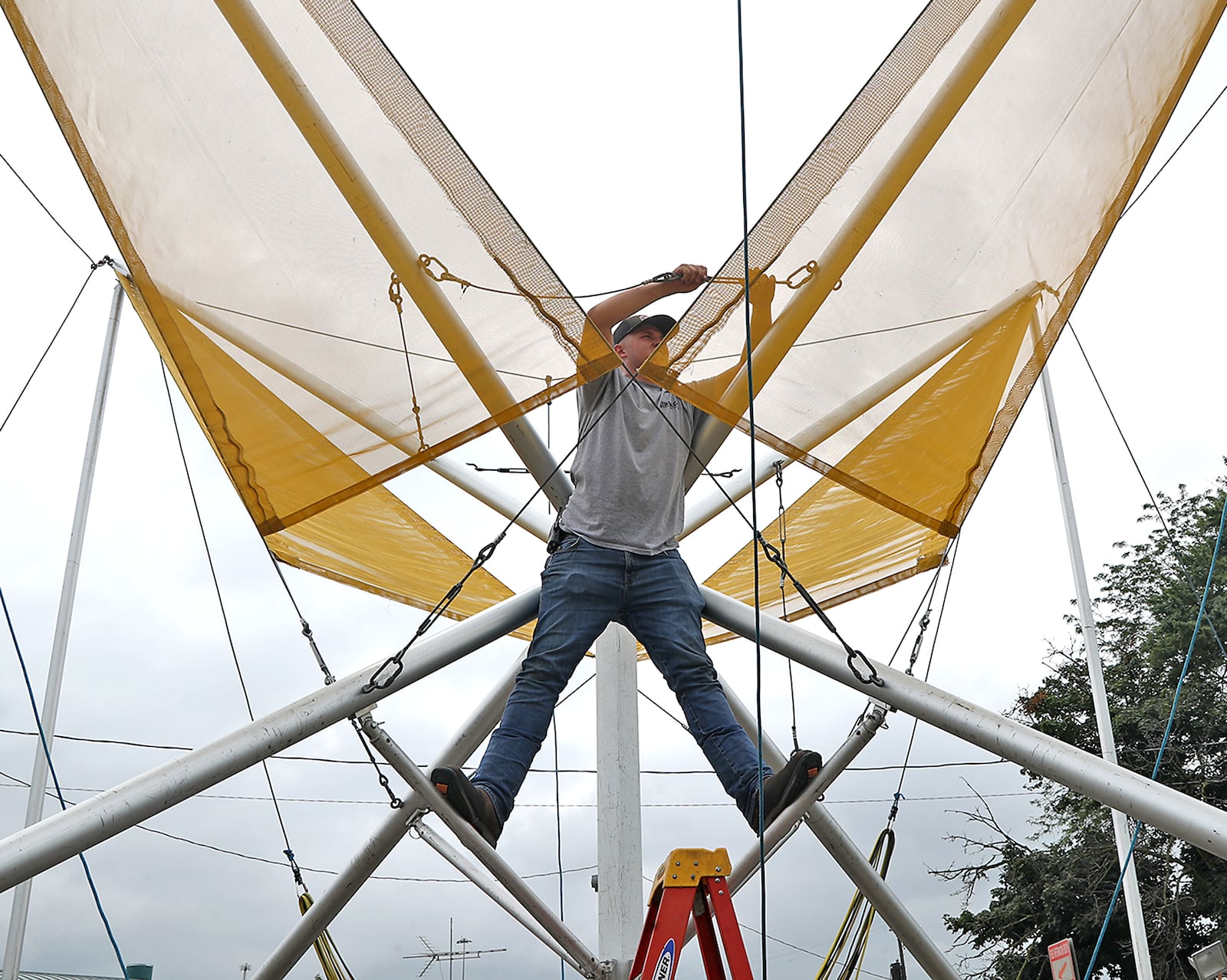 James Euton, an employee of Durant Amusements, sets up the Bungee Jump ride at the Clark County Fair Monday, July 18, 2022. BILL LACKEY/STAFF