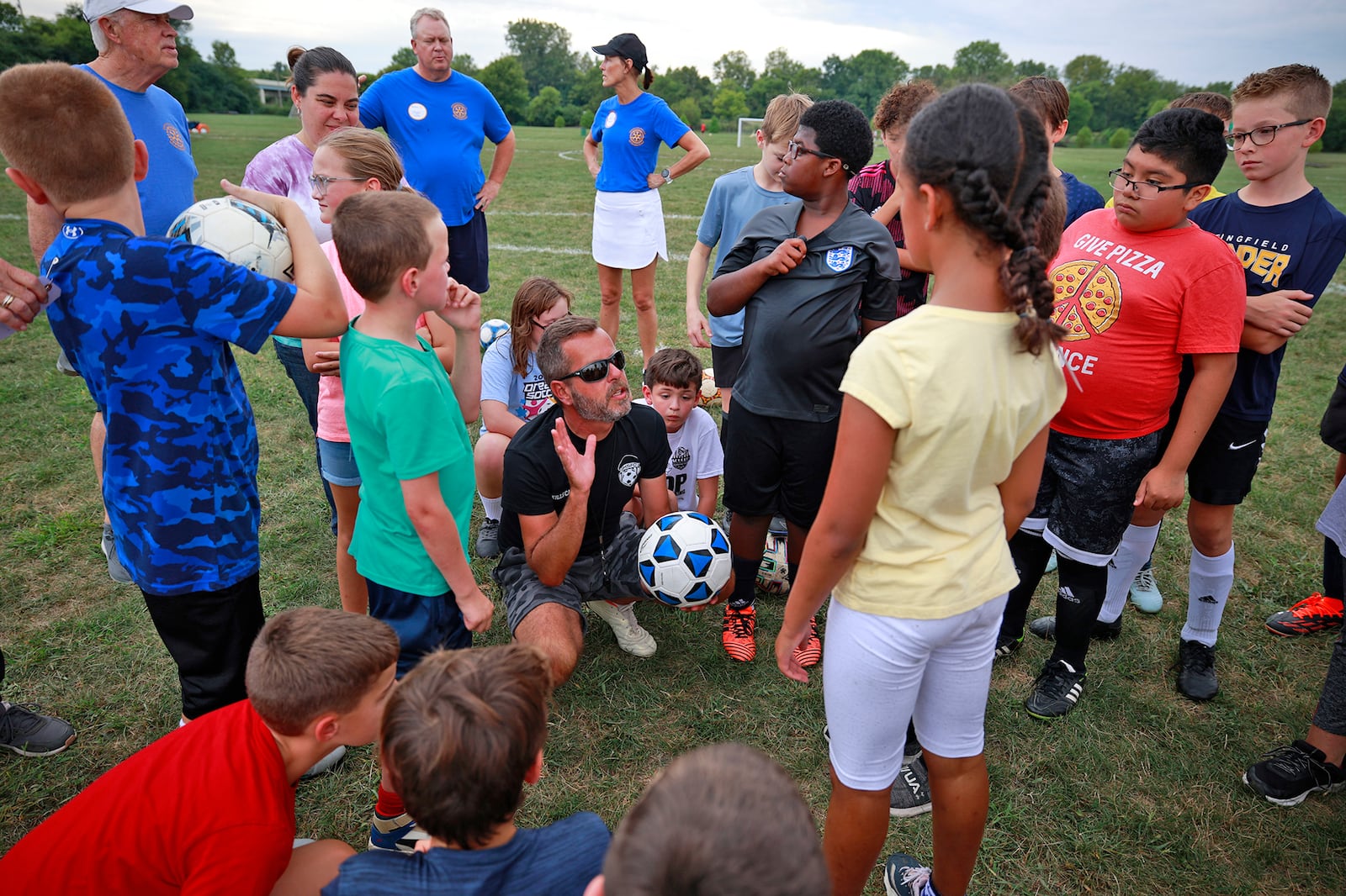 Coach Tony Cooper, center, calls the players together to go over passing the ball during practice Thursday, August 15, 2024 for the 18th Annual Dream Soccer Tournament on Friday. BILL LACKEY/STAFF