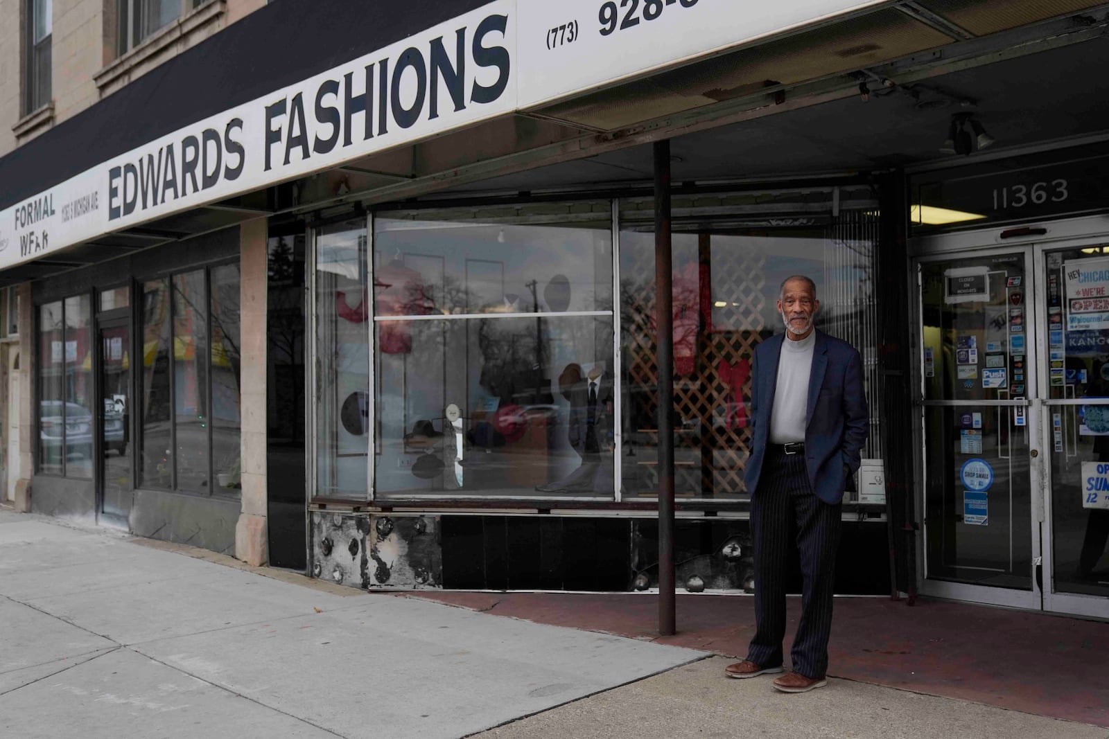 Ledall Edwards stands outside his family's men's clothing store, Edward's Fashions, which his father opened 50 years ago with the hopes of a southern Red Line train line expansion, Thursday, Dec. 19, 2024, in the Roseland neighborhood of Chicago. (AP Photo/Erin Hooley)