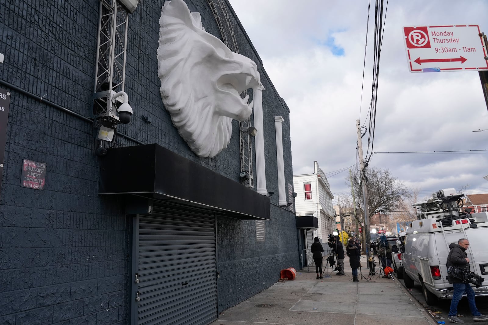 Members of the media work in front of the nightclub Amazura, left, in the Queens borough of New York, Thursday, Jan. 2, 2025. (AP Photo/Seth Wenig)