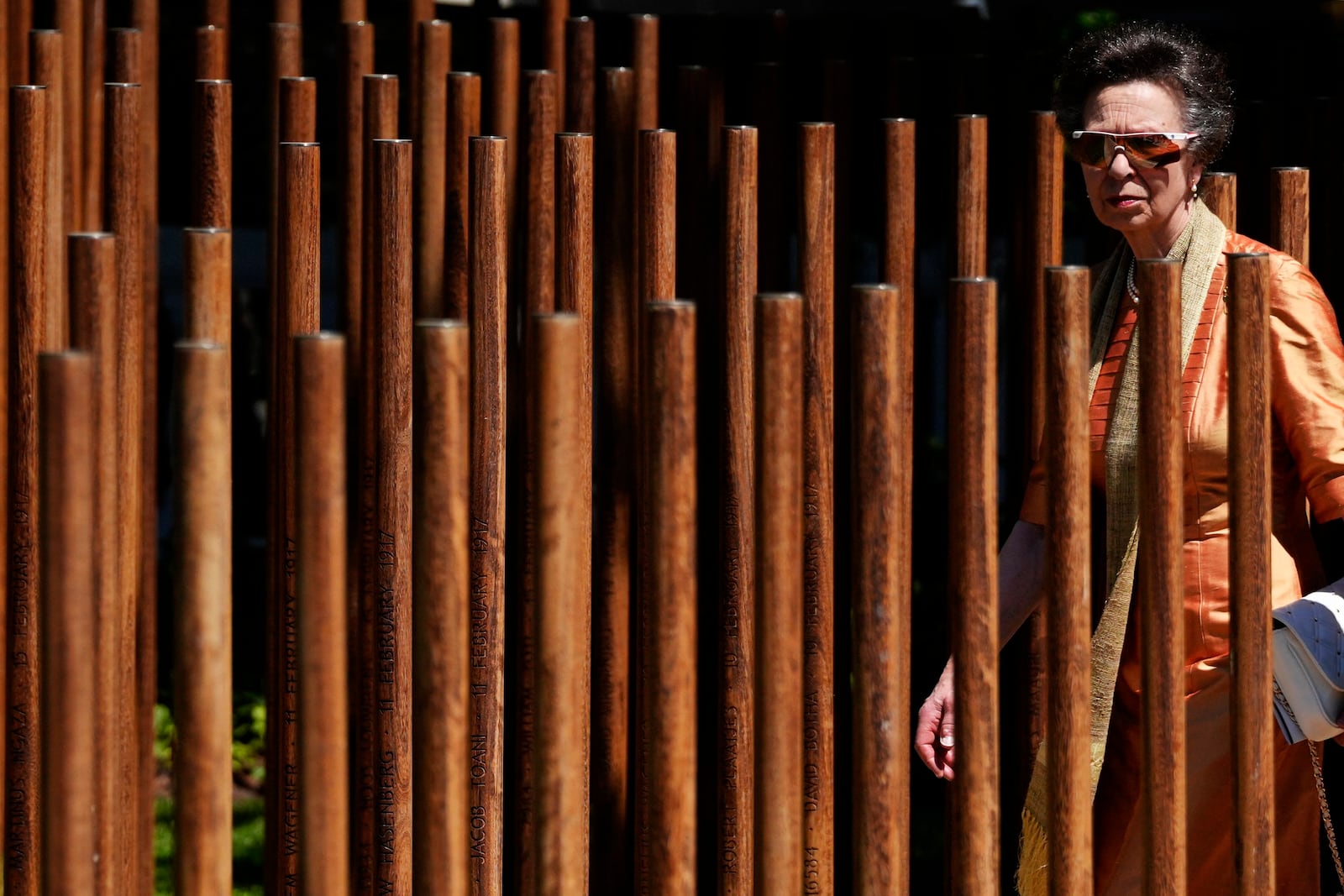 Britain's Princess Anne, the President of the Commonwealth War Graves Commission, walks in between an African "iroko" hardwood post bearing names and the date of death of 1,700 Black South African servicemen who died in non-combatant roles in World War I and have no known grave, in Cape Town, South Africa, Wednesday, Jan. 22, 2025. (AP Photo/Nardus Engelbrecht)