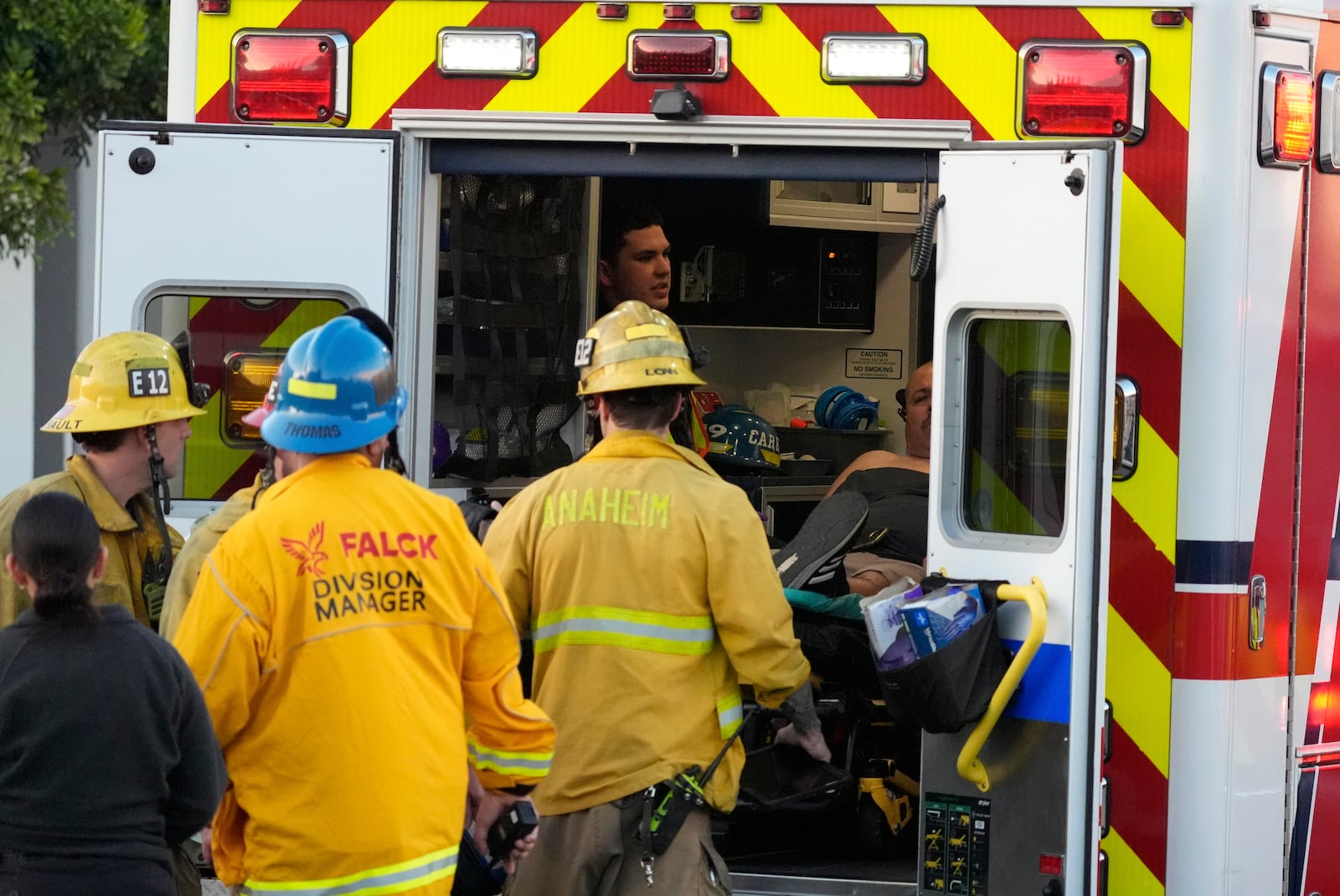 Firefighters load a person onto an ambulance after a small plane crashed into a commercial building on Thursday, Jan. 2, 2025, in Fullerton, Calif. (AP Photo/Damian Dovarganes)