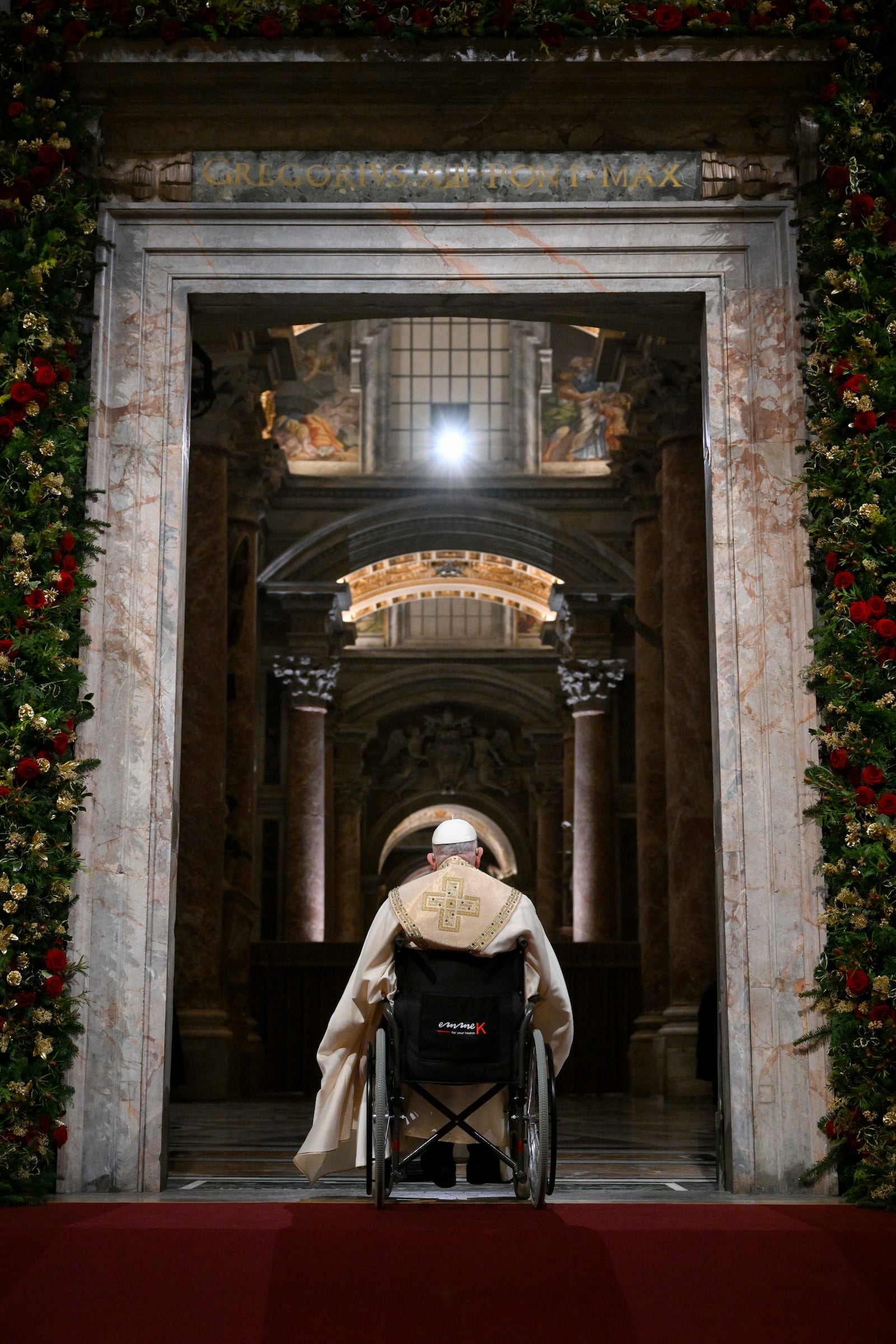 In this image released by Vatican Media, Pope Francis opens the holy door marking the start of the Catholic jubilar year 2025 before presiding over the Christmas Eve Mass in St. Peter's Basilica at The Vatican, Tuesday, Dec. 24, 2024. (AP Photo/Vatican Media, HO)