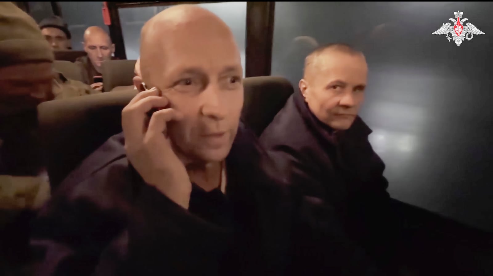 In this photo taken from video released by the Russian Defense Ministry Press Service on Monday, Dec. 30, 2024, a Russian soldier speaks on the phone with his relatives as he and others sit in a bus after being released in a prisoners swap between Russia and Ukraine, at an unspecified location in Belarus. (Russian Defense Ministry Press Service via AP)