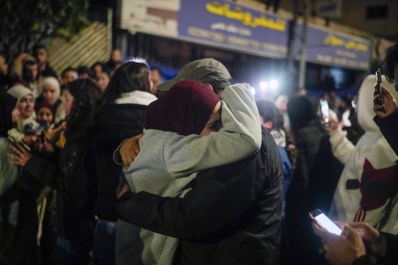 A female Palestinian prisoner, center left, is greeted after disembarking from a bus following her release from an Israeli prison, in the West Bank city of Beitunia, early Monday, Jan. 20, 2025. (AP Photo/Leo Correa)