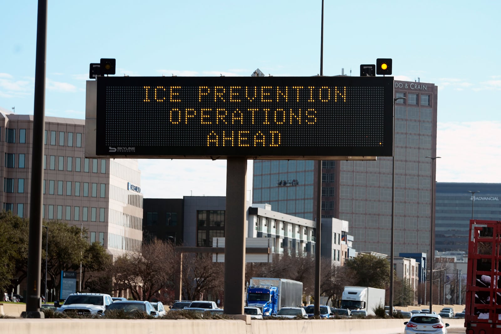 A sign warns drivers of ice prevention operations ahead of a winter storm expected to hit the North Texas region later this week, Tuesday, Jan. 7, 2025, in Dallas. (AP Photo/LM Otero)