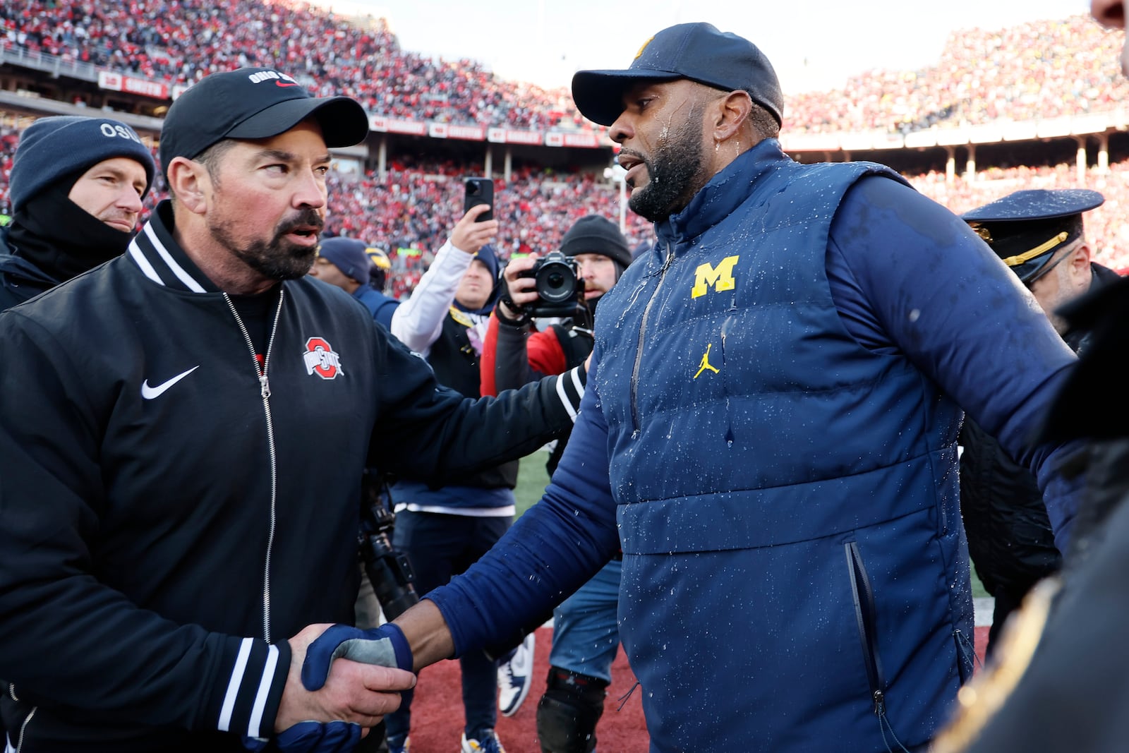 Ohio State head coach Ryan Day, left, and Michigan head coach Sherrone Moore shake hands after an NCAA college football game Saturday, Nov. 30, 2024, in Columbus, Ohio. (AP Photo/Jay LaPrete)