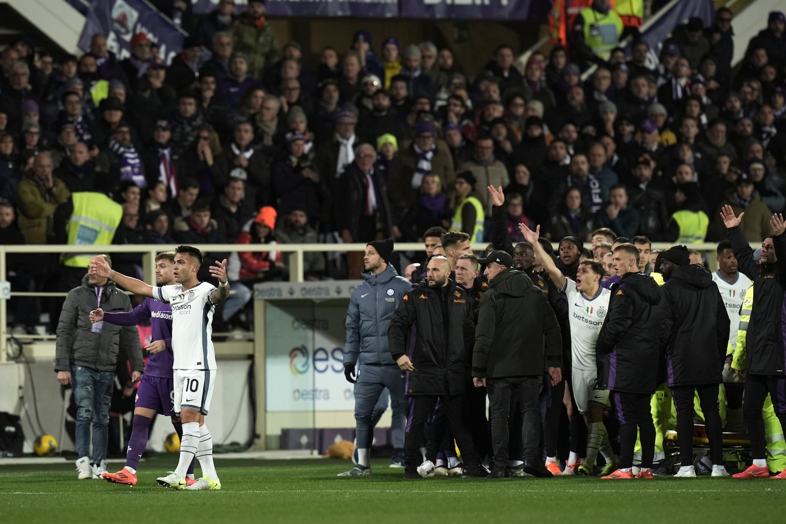 An ambulance enters the field as Fiorentina's Edoardo Bove, injured, is surrounded by players during the Serie A soccer match between Fiorentina and Inter at the Artemio Franchi Stadium in Florence, Italy, Sunday Dec. 1, 2024. The match was suspended and finally postponed as the injures appeared to be serious. (Massimo Paolone/LaPresse via AP)