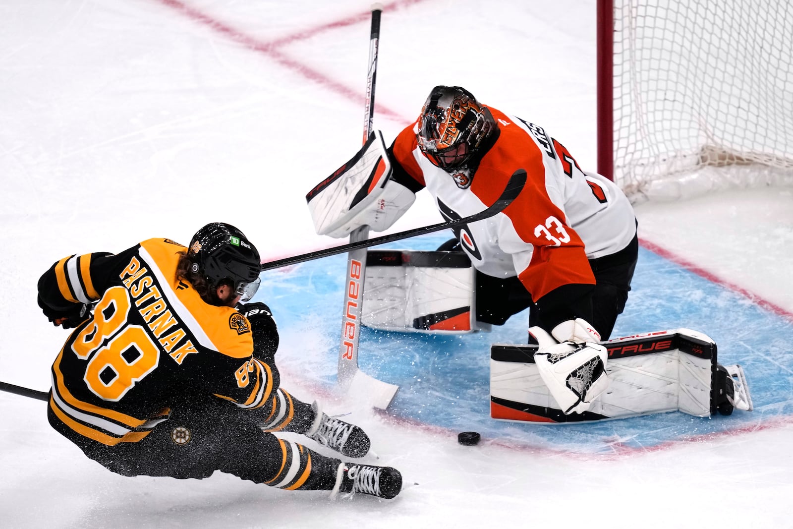 Philadelphia Flyers goaltender Samuel Ersson (33) drops to the ice to make a save on a shot by Boston Bruins right wing David Pastrnak (88) during the first period of an NHL hockey game, Tuesday, Oct. 29, 2024, in Foxborough, Mass. (AP Photo/Charles Krupa)