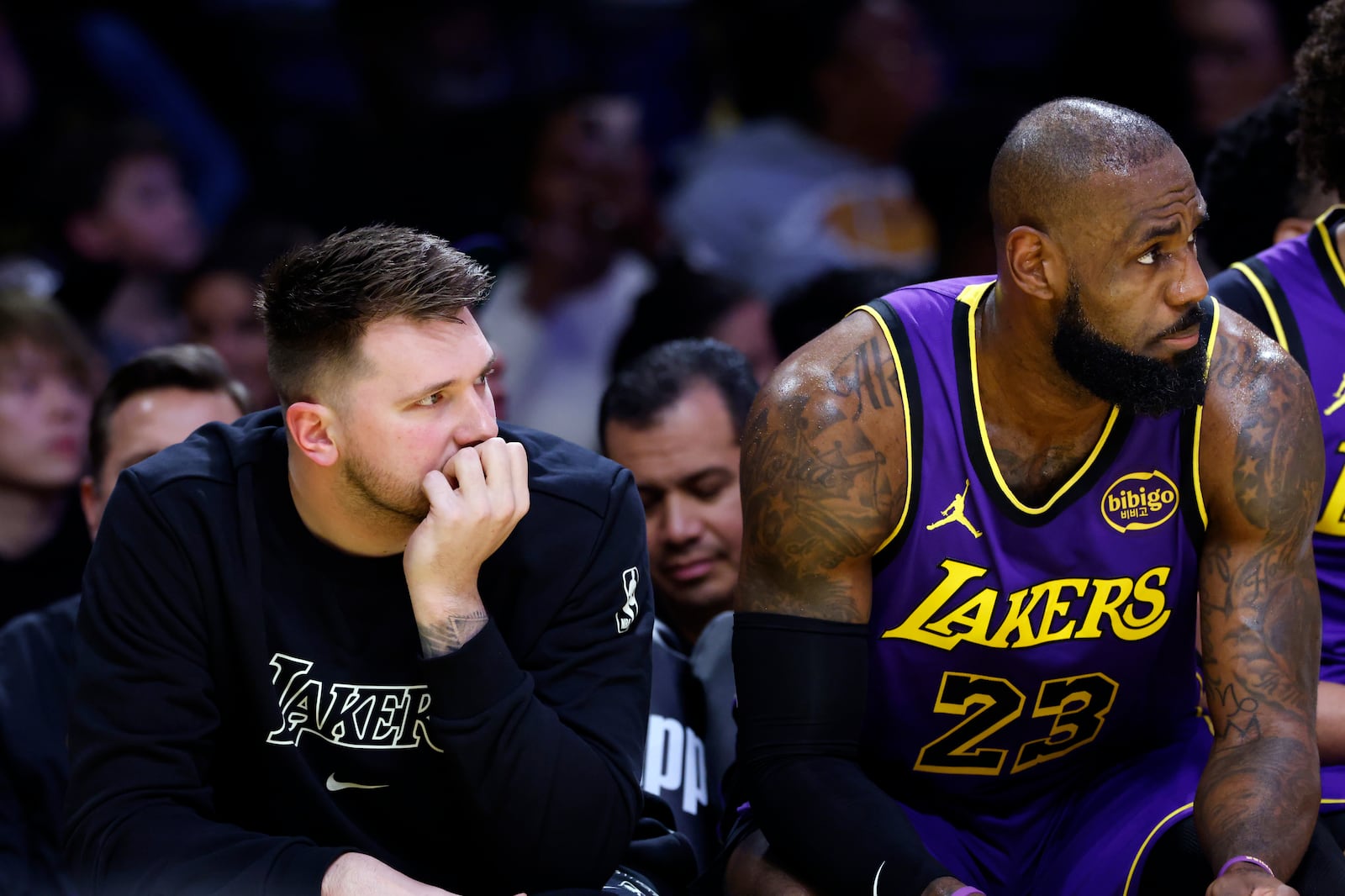 Los Angeles Lakers guard Luka Doncic, left, and forward LeBron James, right, follow the action on the floor from the bench during the first half of an NBA basketball game against the Golden State Warriors, Thursday, Feb. 6, 2025, in Los Angeles. (AP Photo/Kevork Djansezian)