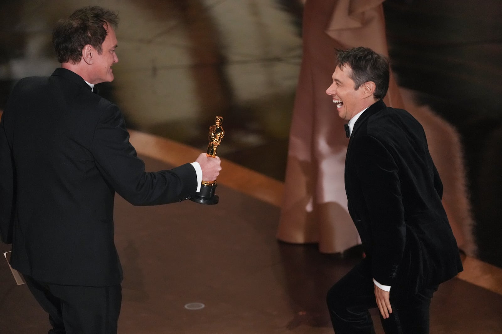 Quentin Tarantino, left, presents the award for best director to Sean Baker for "Anora" during the Oscars on Sunday, March 2, 2025, at the Dolby Theatre in Los Angeles. (AP Photo/Chris Pizzello)