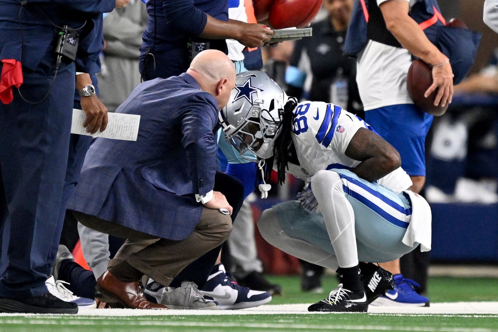 Dallas Cowboys wide receiver CeeDee Lamb (88) is checked on by team medical staff after Lamb caught a pass in the first half of an NFL football game against the Tampa Bay Buccaneers in Arlington, Texas, Sunday, Dec. 22, 2024. (AP Photo/Jerome Miron)