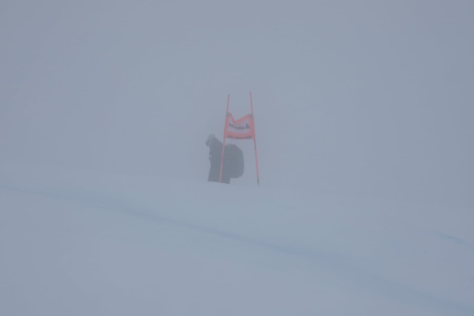 A gate is barely seen through the fog as an alpine ski, women's World Cup Super G race was canceled due to strong winds and poor visibility, in St. Moritz, Switzerland, Sunday, Dec. 22, 2024. (AP Photo/Marco Trovati)