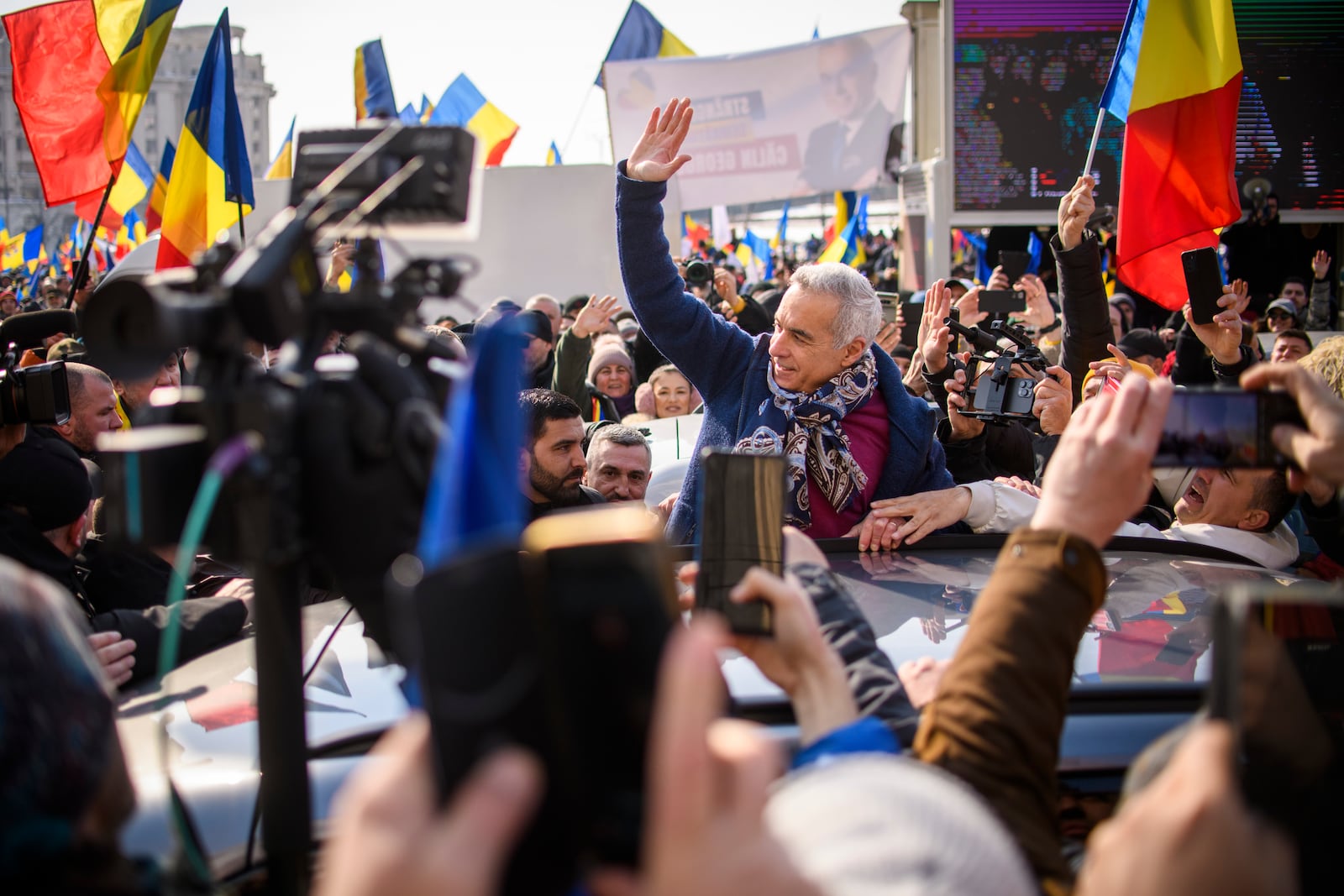 Calin Georgescu, the winner of Romania's first round of presidential election, annulled by the Constitutional Court, waves to supporters gathered for a protest outside the Romanian parliament in Bucharest, Romania, Saturday, Feb. 22, 2025. (AP Photo/Alexandru Dobre)