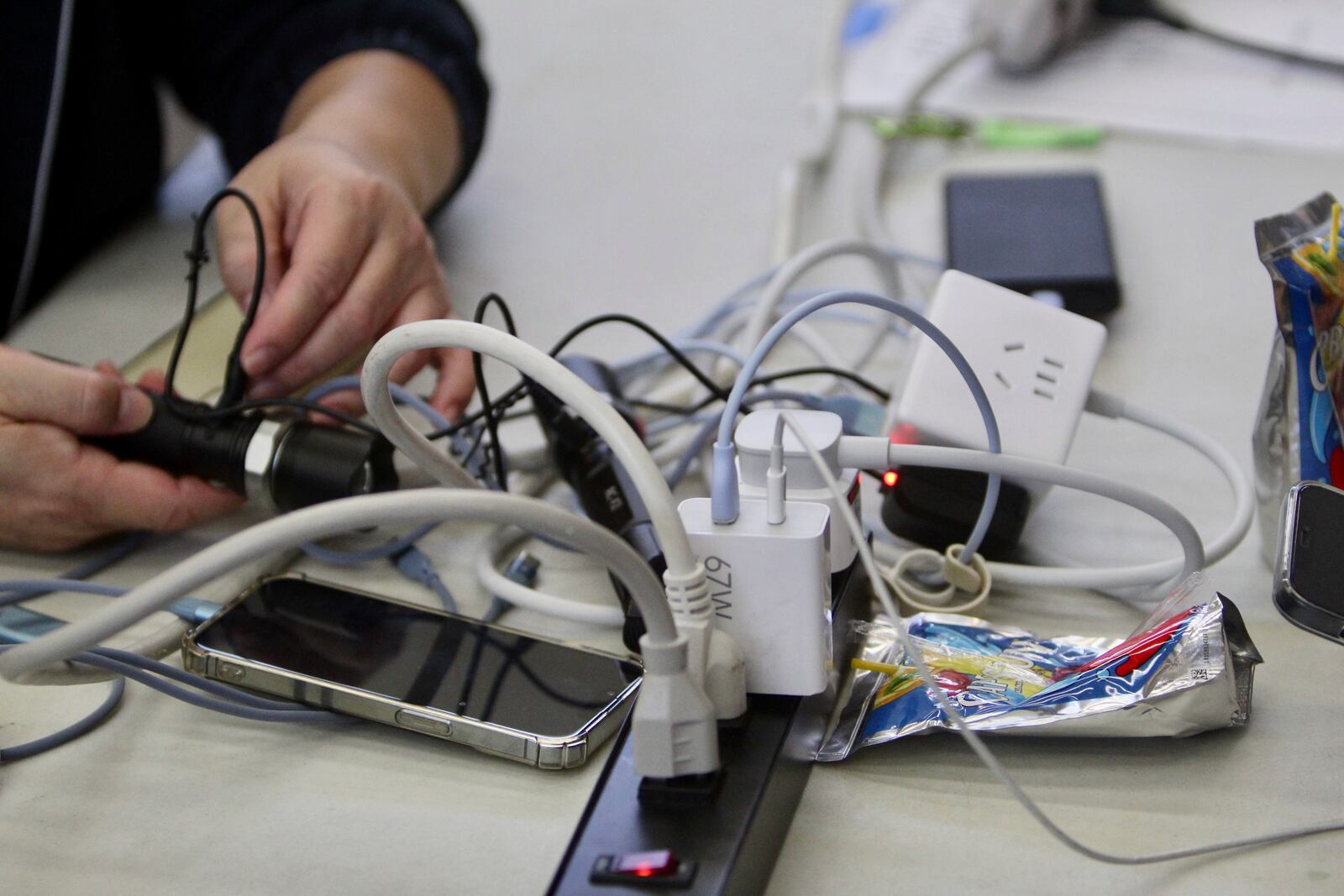 People gather to charge their electronics at a charging station set up at the Issaquah Senior Center in Issaquah, Wash., Friday, Nov. 22, 2024. (AP Photo/Manuel Valdes)