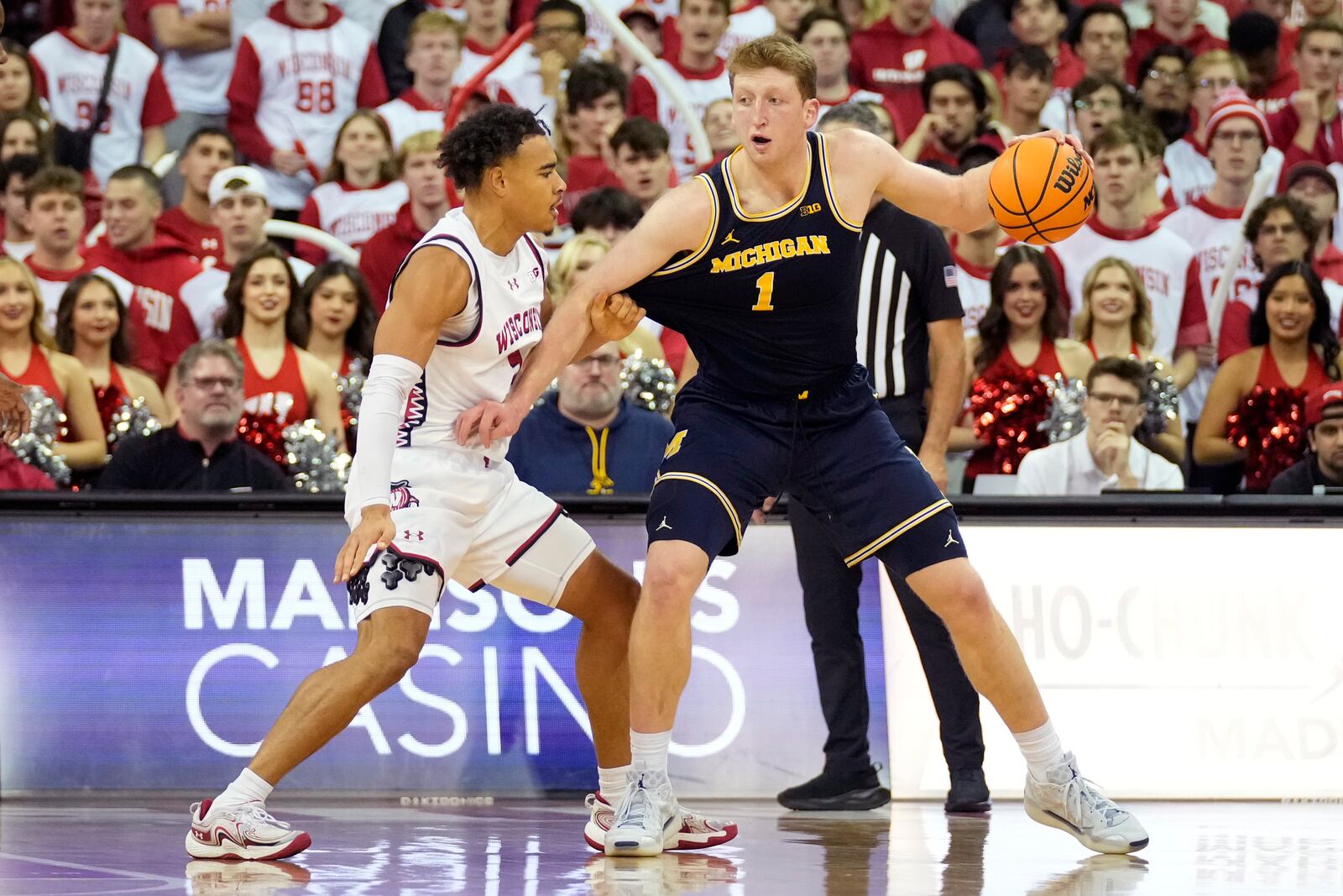 Michigan center Danny Wolf (1) dribbles the ball against Wisconsin guard John Tonje (9) during the second half of an NCAA college basketball game Tuesday, Dec. 3, 2024, in Madison, Wis. Michigan won 67-64. (AP Photo/Kayla Wolf)