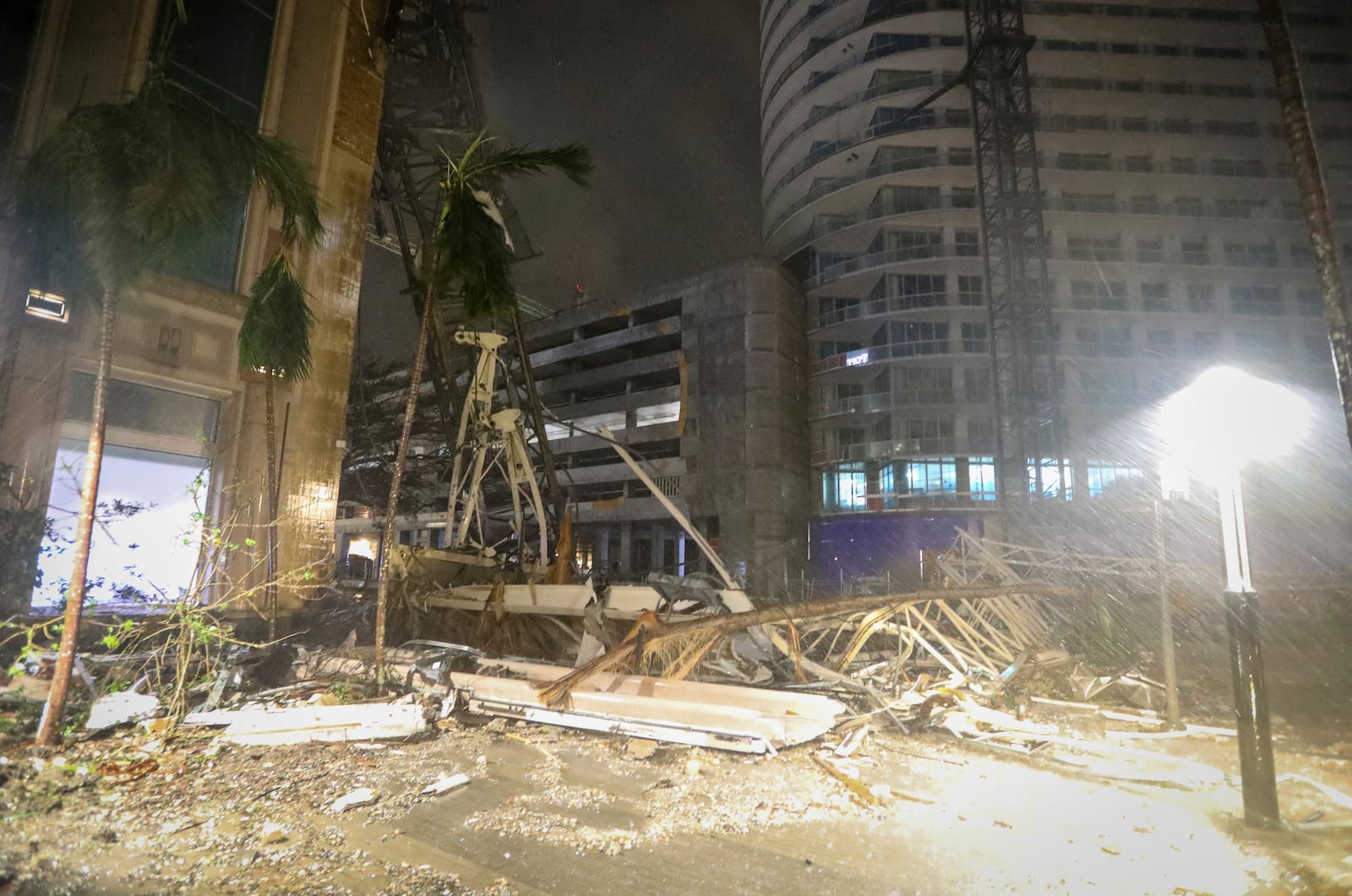 Debris covers the ground near a crane that fell onto a building along 1st Avenue South in St. Petersburg, Fla., as Hurricane Milton's strong winds tore through the area Thursday, Oct. 10, 2024. (Chris Urso/Tampa Bay Times via AP)