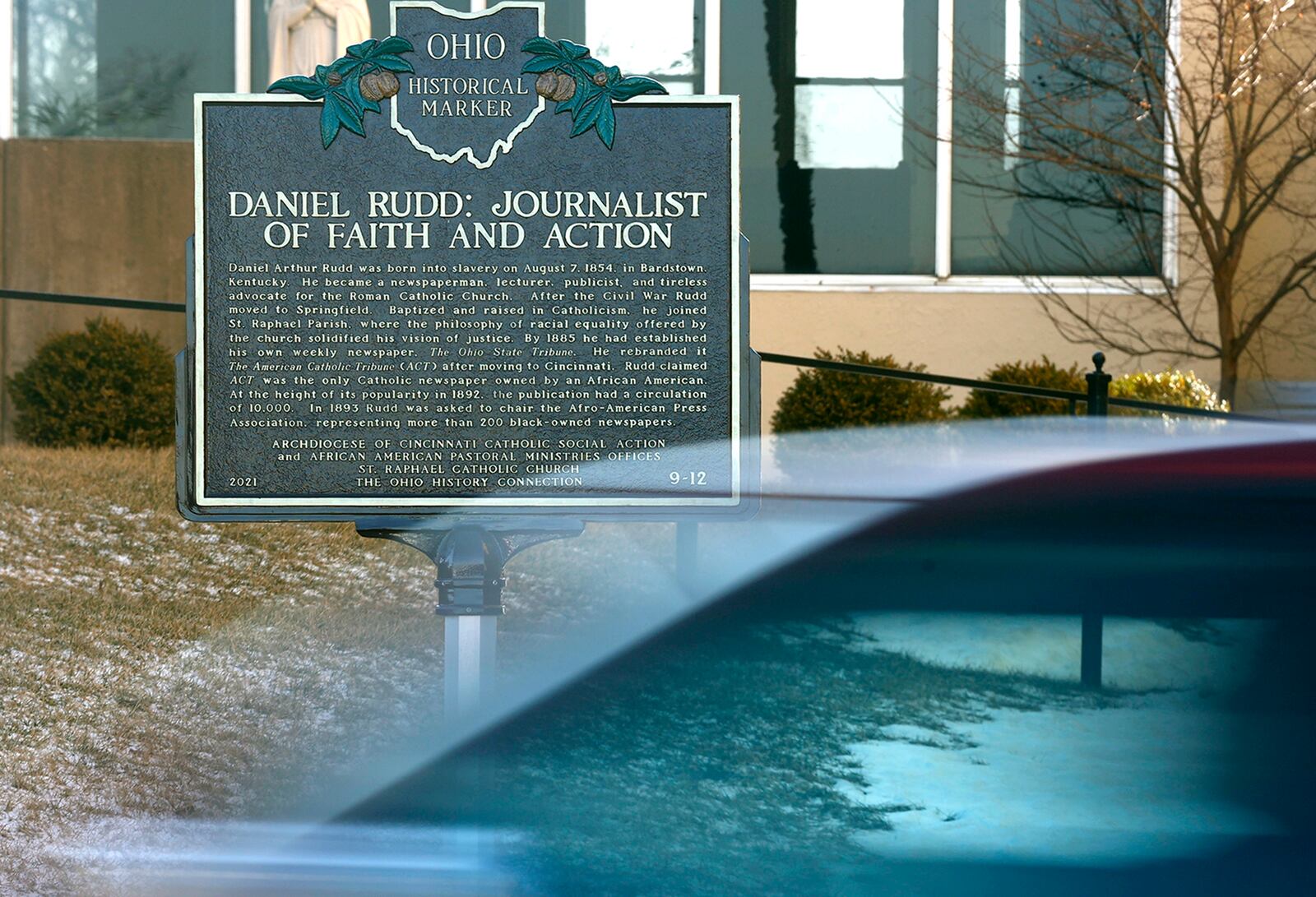 A car speeds past the Ohio Historical Marker honoring Daniel Rudd, a local Black journalist and activist, along East High Street in Springfield. The marker is one of three recent public displays honoring local Black history achievements. BILL LACKEY/STAFF