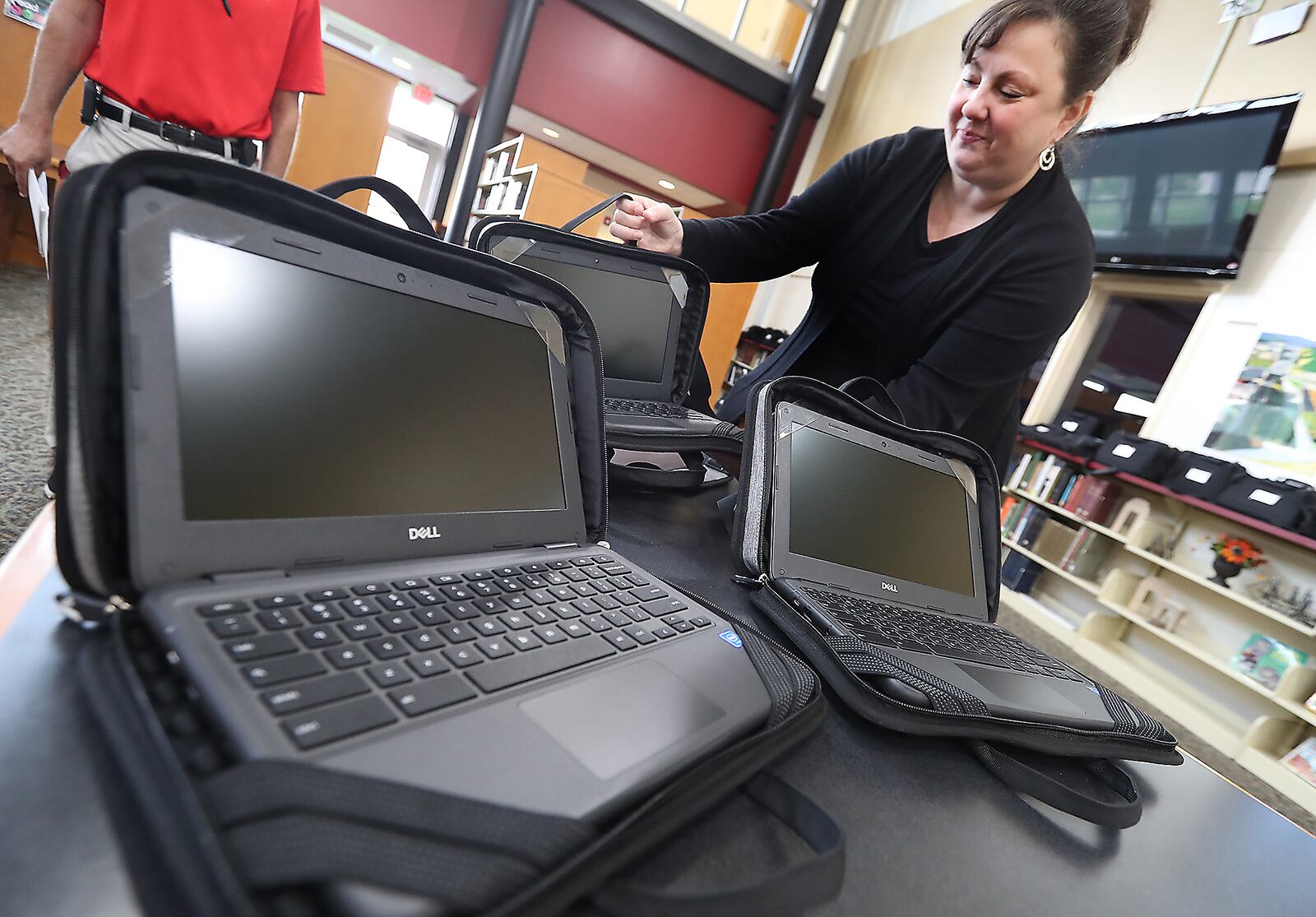 Rachel Brown unpacks some of the hundreds of Chromebooks that Tecumseh Schools purchased with part of their relief money Wednesday. BILL LACKEY/STAFF