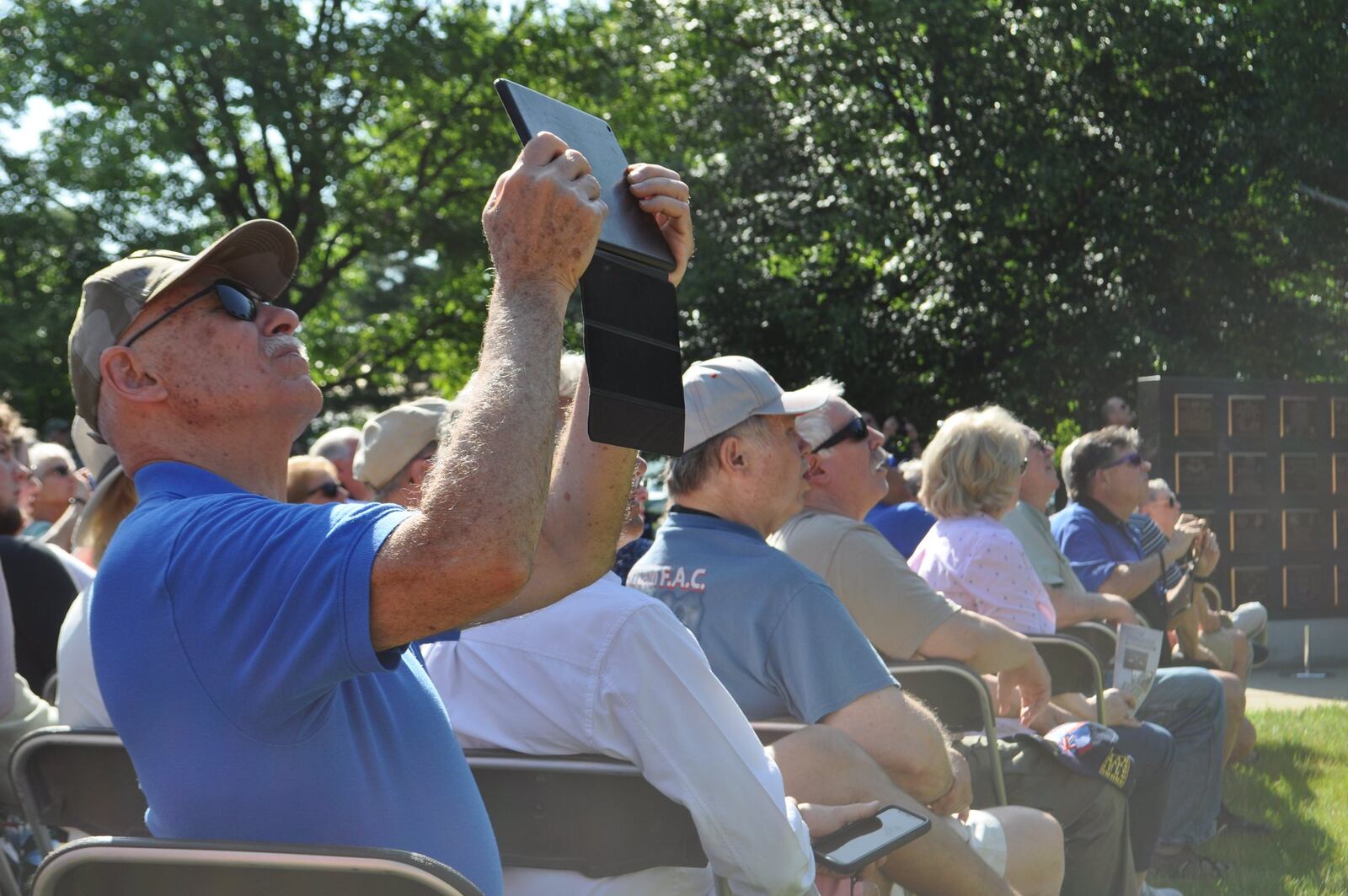 Spectators watch as two C-47 aircraft fly over Memorial Park at the National Museum of the U.S. Air Force on Thursday. The World War II era aircraft flew over the museum as part of a day of events to commemorate the 75th anniversary of D-Day.