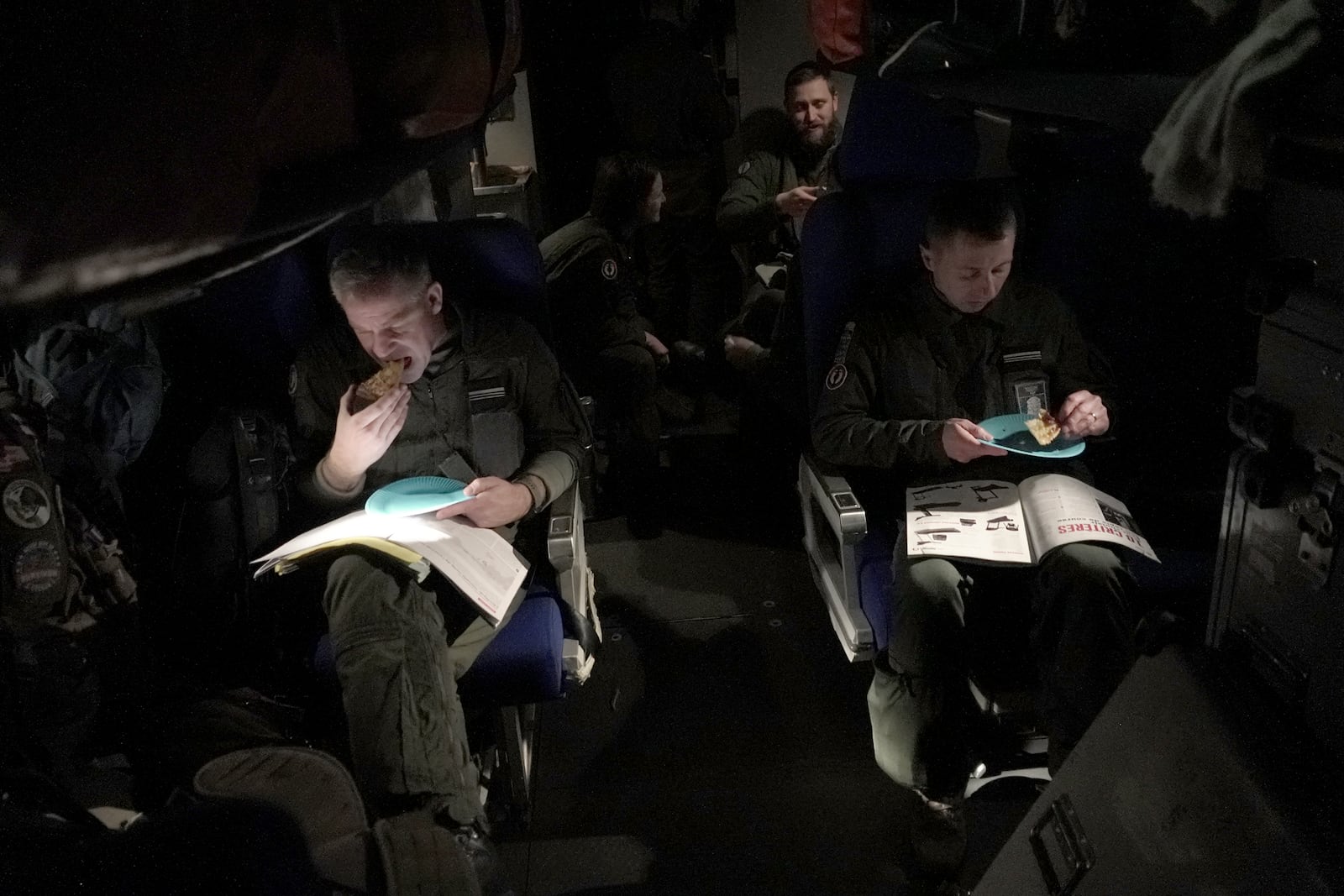 Crew members aboard a French Navy Atlantique 2 surveillance plane take a break as the aircraft flies back to base in Lorient, France, at the tail end of a 15-hour mission on Thursday, Jan. 23, 2025, after patrolling over the Baltic Sea as part of the NATO military alliance's "Baltic Sentry" mission to protect undersea cables and pipelines from sabotage. (AP Photo/John Leicester)