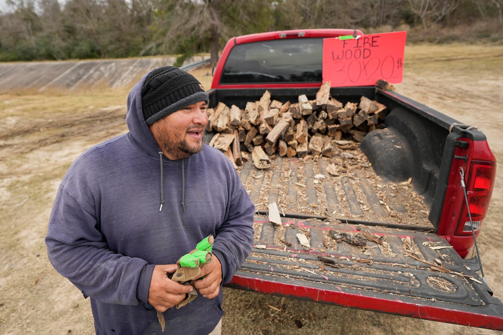 William Amaya sells firewood Monday, Jan. 20, 2025, in Houston, ahead of a winter storm predicted to dump several inches of snow in Southeast Texas. (AP Photo/David J. Phillip)