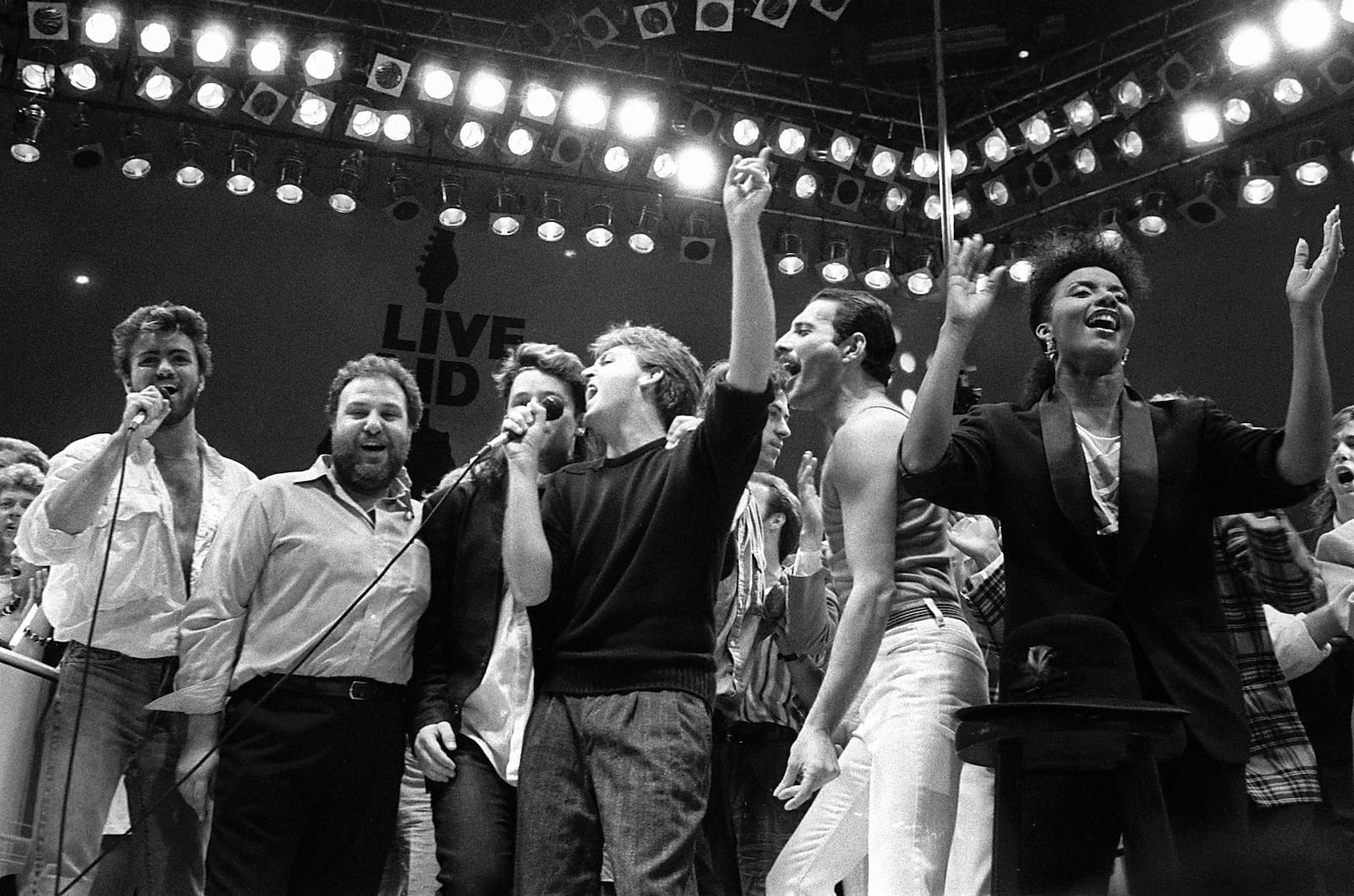 FILE - George Michael, from left, concert promoter Harvey Goldsmith, Bono of U2, Paul McCartney, concert organizer Bob Geldof and Freddie Mercury of Queen join in the finale of the Live Aid famine relief concert, at Wembley Stadium, London on July 13, 1985. (AP Photo/Joe Schaber, File)