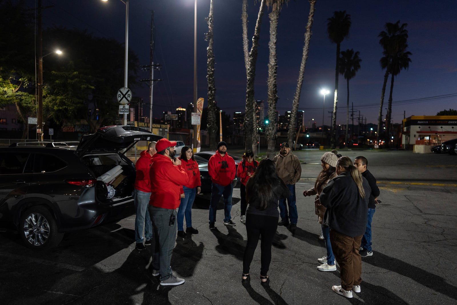 Volunteers working with Union del Barrio, an organization advocating for immigrant rights, gather in a parking lot before heading out to search for ICE activity in Los Angeles Thursday, Feb. 27, 2025. (AP Photo/Jae C. Hong)