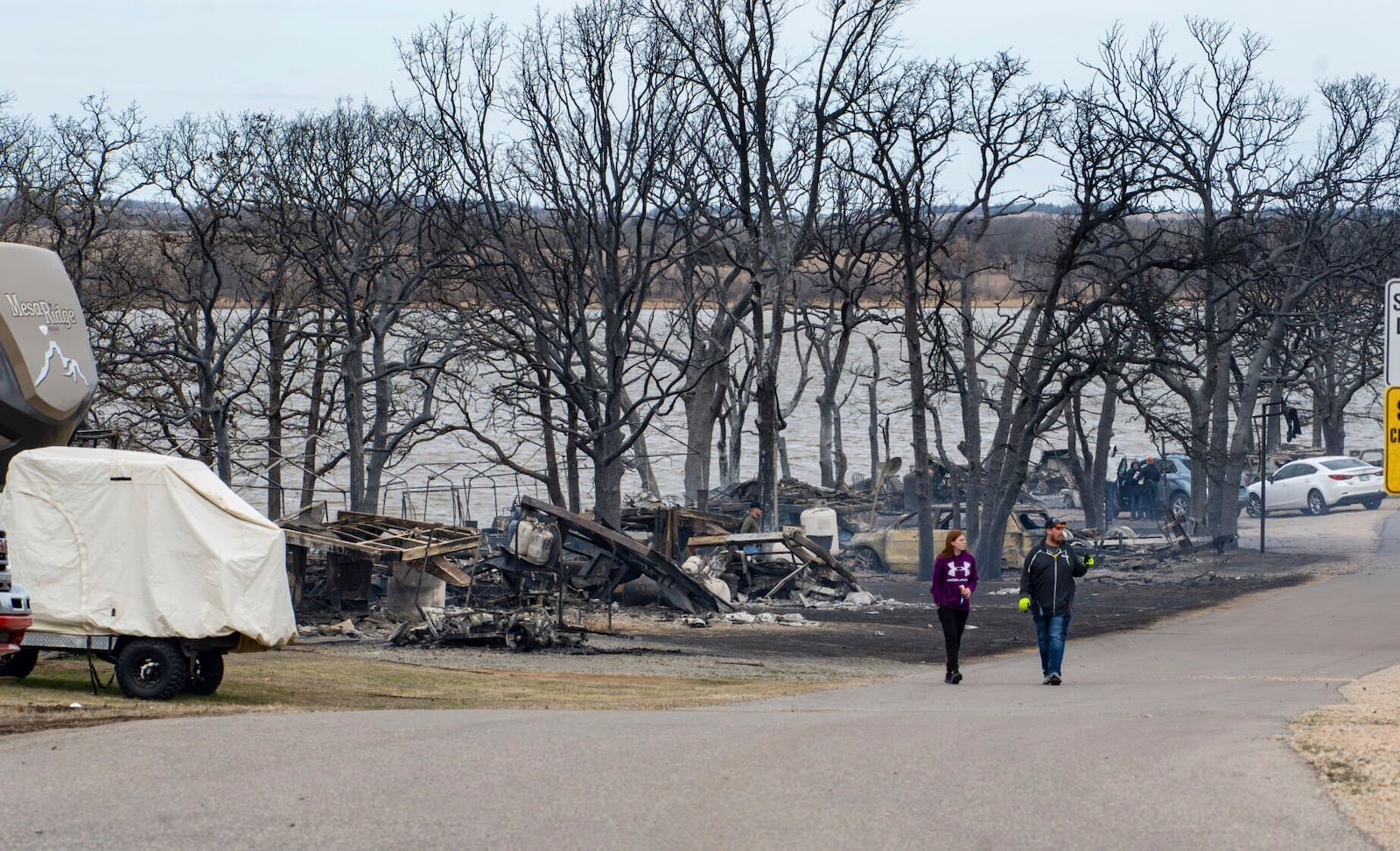 Residents of Deer Run at Lake Carl Blackwell, near Stillwater, Okla., on Saturday, March 15, 2025, assess the damage from Friday's wildfires. (Jason Elmquist/The News Press via AP)