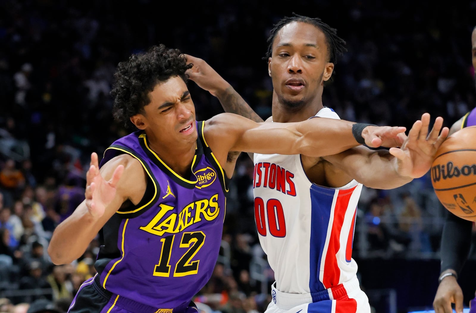 Detroit Pistons forward Ronald Holland II (00) knocks the ball away from Los Angeles Lakers guard Max Christie (12) during the first half of an NBA basketball game Monday, Nov. 4, 2024, in Detroit. (AP Photo/Duane Burleson)