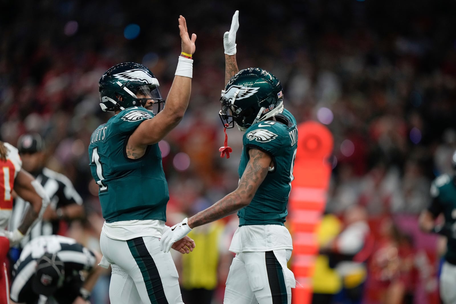 Philadelphia Eagles quarterback Jalen Hurts, left, celebrates with wide receiver DeVonta Smith, right, after a touchdown by wide receiver A.J. Brown during the first half of the NFL Super Bowl 59 football game against the Kansas City Chiefs, Sunday, Feb. 9, 2025, in New Orleans. (AP Photo/Matt Slocum)