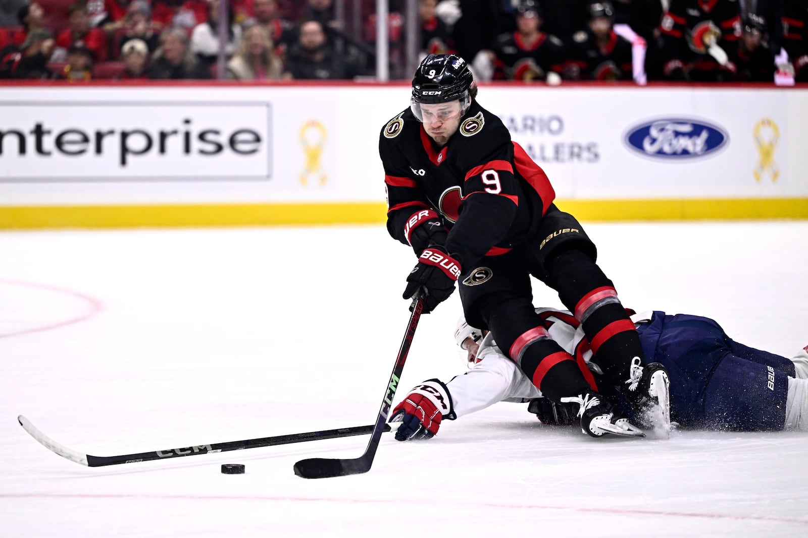 Ottawa Senators' Josh Norris (9) gets tripped by Washington Capitals' John Carlson (74), leading to Norris' penalty shot goal, during second period NHL hockey action in Ottawa, on Thursday, Jan. 30, 2025. (Justin Tang/The Canadian Press via AP)