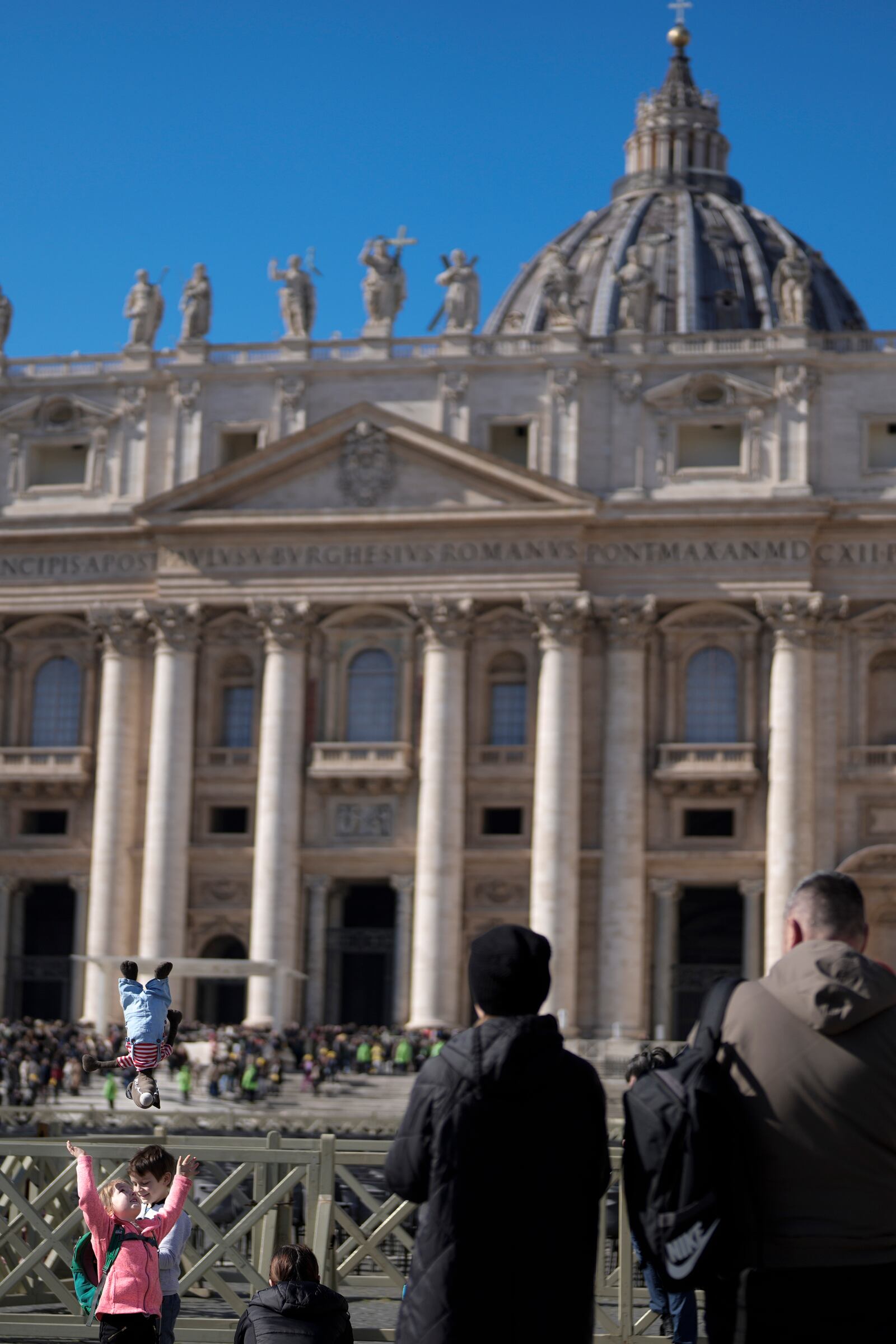 Families wait under the closed window of the Apostolic Palace at The Vatican, Sunday, Feb. 16, 2025, from where Pope Francis, who was hospitalised on Friday, blesses the faithful gathered in St. Peter's Square after the Angelus every Sunday. (AP Photo/Gregorio Borgia)