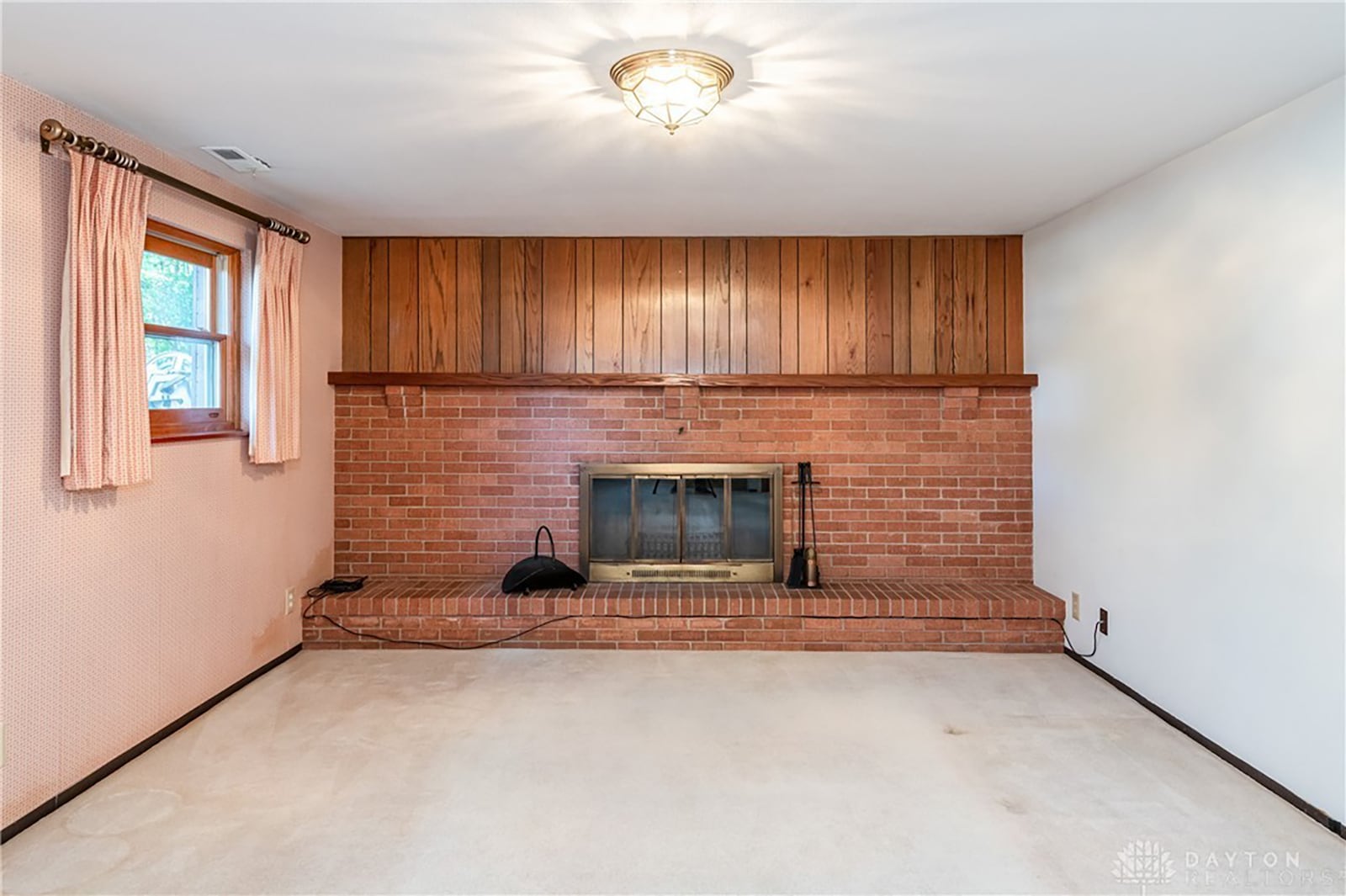 The lower level has a finished family room with woodburning fireplace and a brick raised hearth.