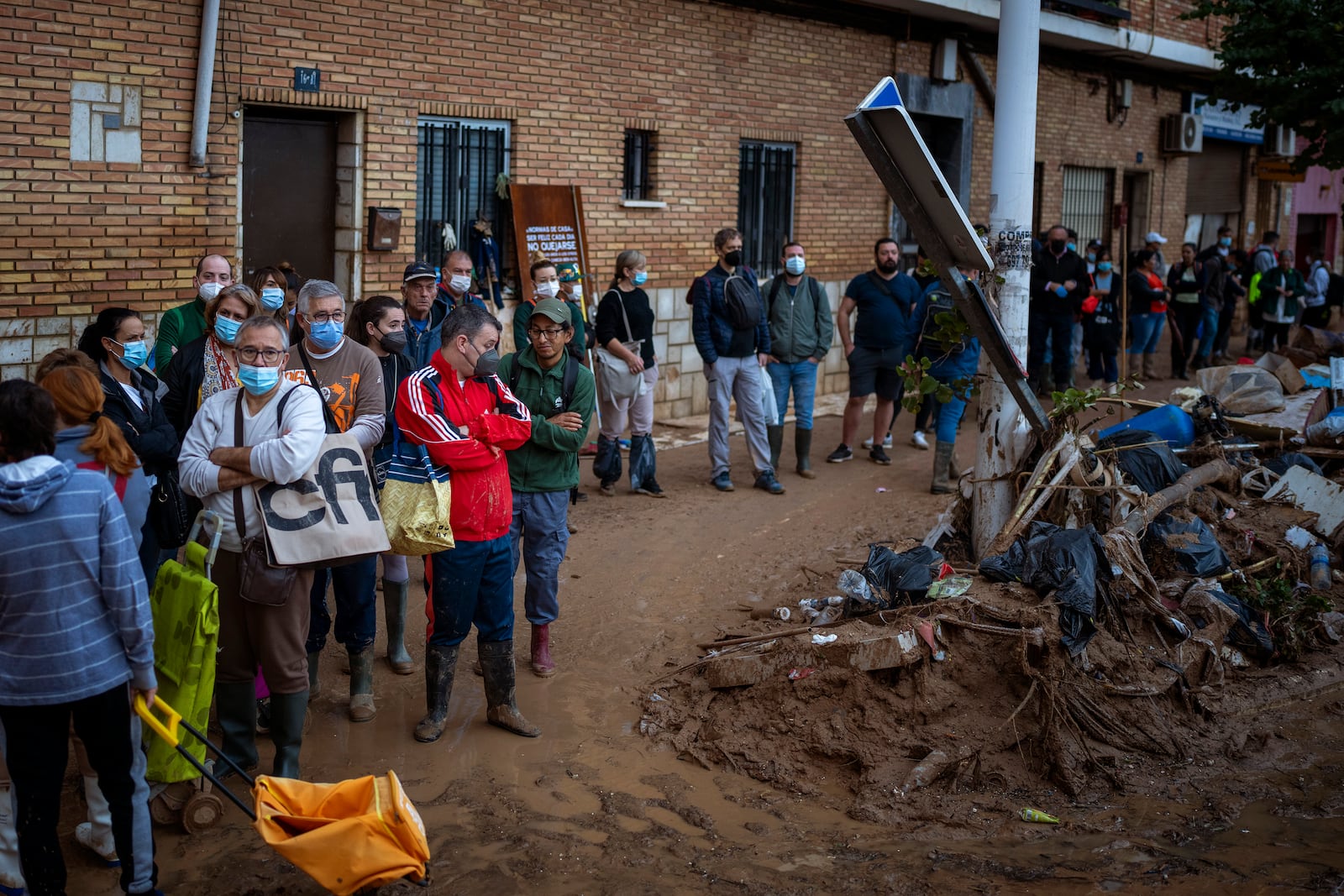 Residents wait for public transportation in an area, affected by floods, in Paiporta, Valencia, Spain, Tuesday, Nov. 5, 2024. (AP Photo/Emilio Morenatti)