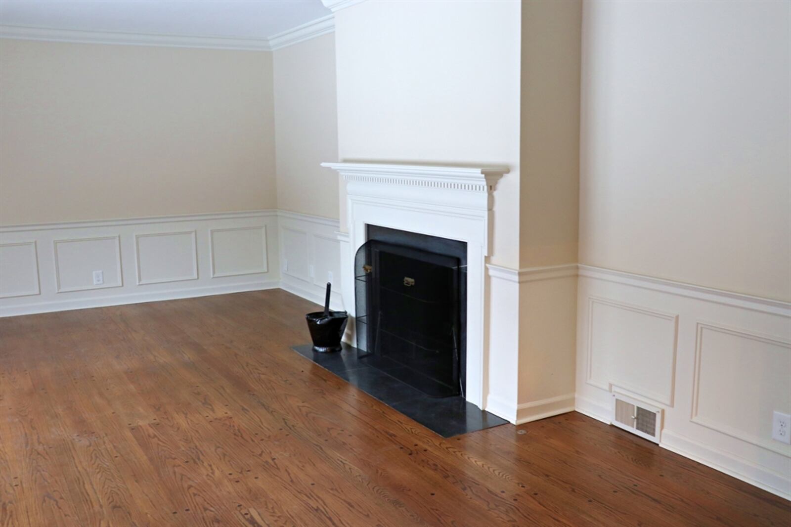 The formal living room has a handsome fireplace with a dentil wood mantel and black granite hearth. Crown molding and wainscoting add elegance and match the formal dining room.