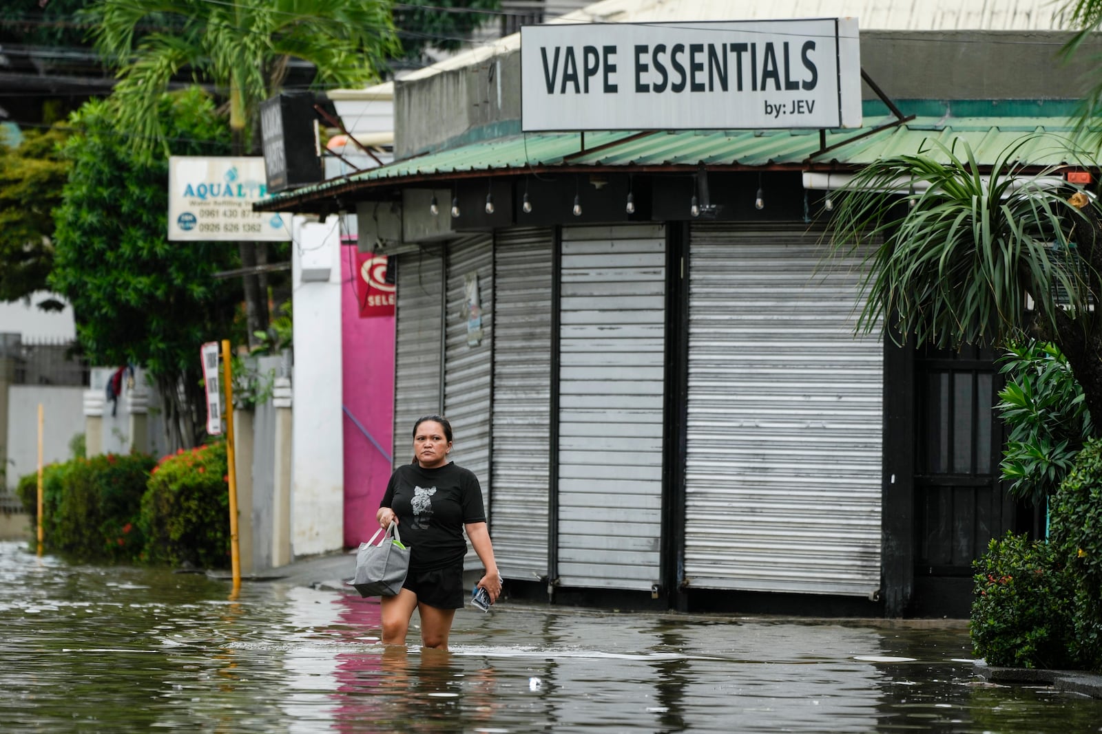 A resident crosses flooded streets caused by Tropical Storm Trami on Friday, Oct. 25, 2024, in Cainta, Rizal province, Philippines. (AP Photo/Aaron Favila)