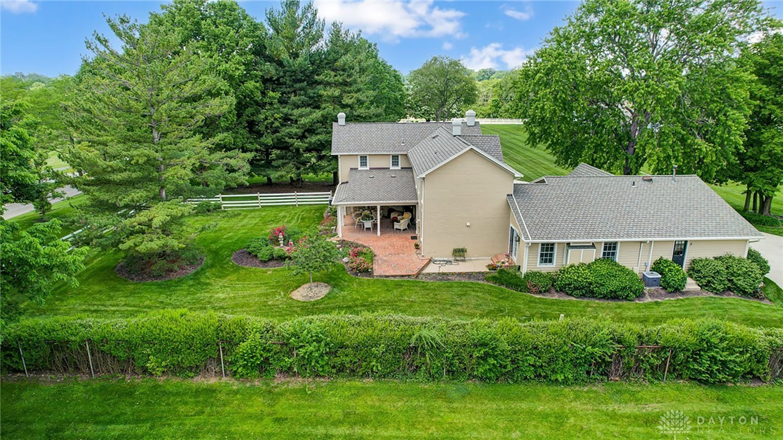 The rear of the home includes a covered brick paver patio and wood fence