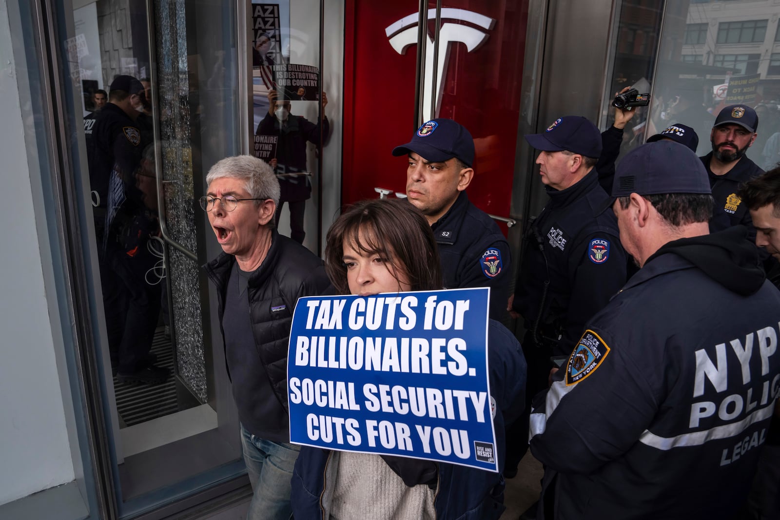 FILE - Demonstrators are arrested by NYPD officers during a protest against Elon Musk and Tesla outside of a Tesla showroom, Saturday, March 1, 2025, in New York. (AP Photo/Adam Gray, File)