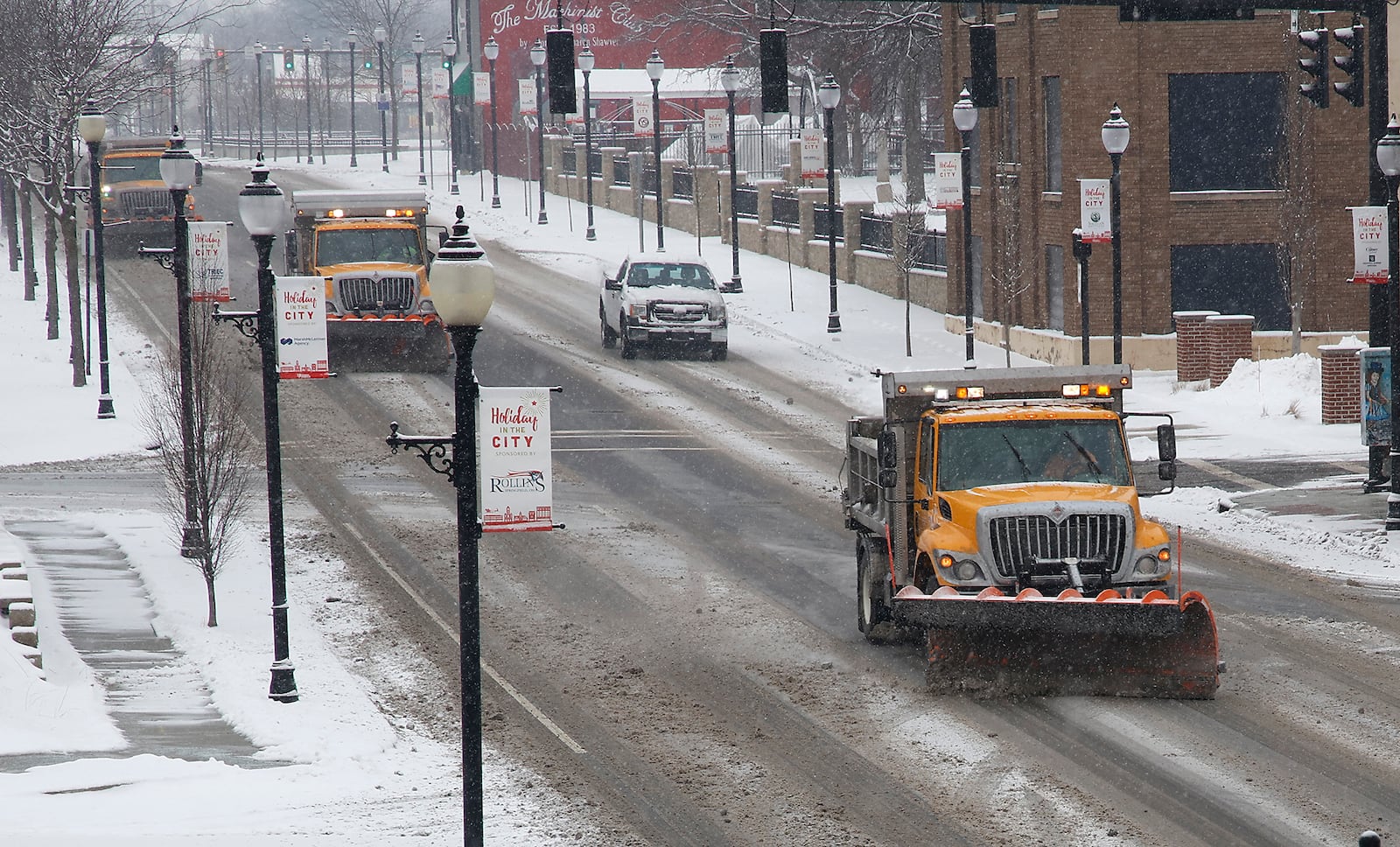 Three City of Springfield snow plows work together to clear Columbia Street in the downtown area Friday, Jan. 19, 2024. BILL LACKEY/STAFF